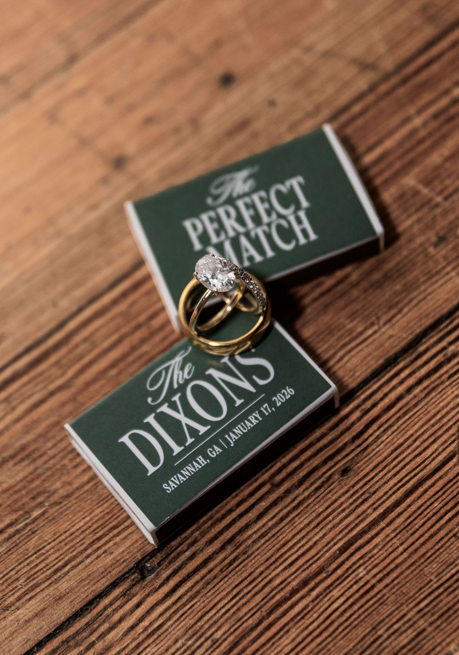 Gold wedding rings resting on green custom matchboxes reading The Perfect Match The Dixons Savannah GA January 17 2026.