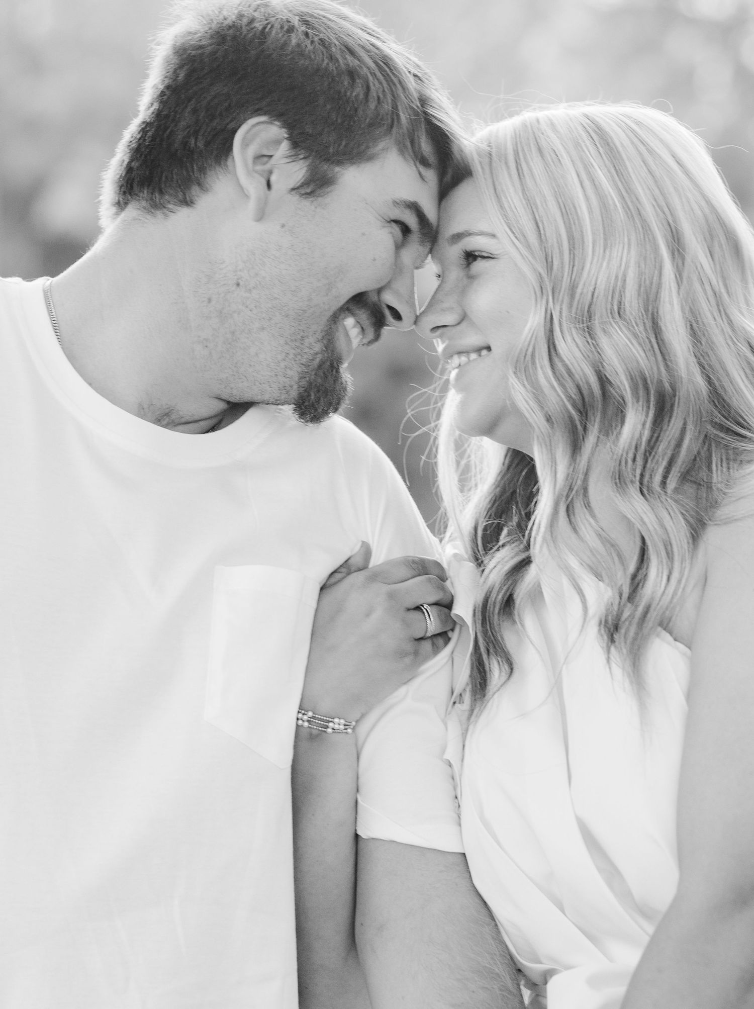 A romantic black and white photo series showing intimate moments between a couple in white clothing.