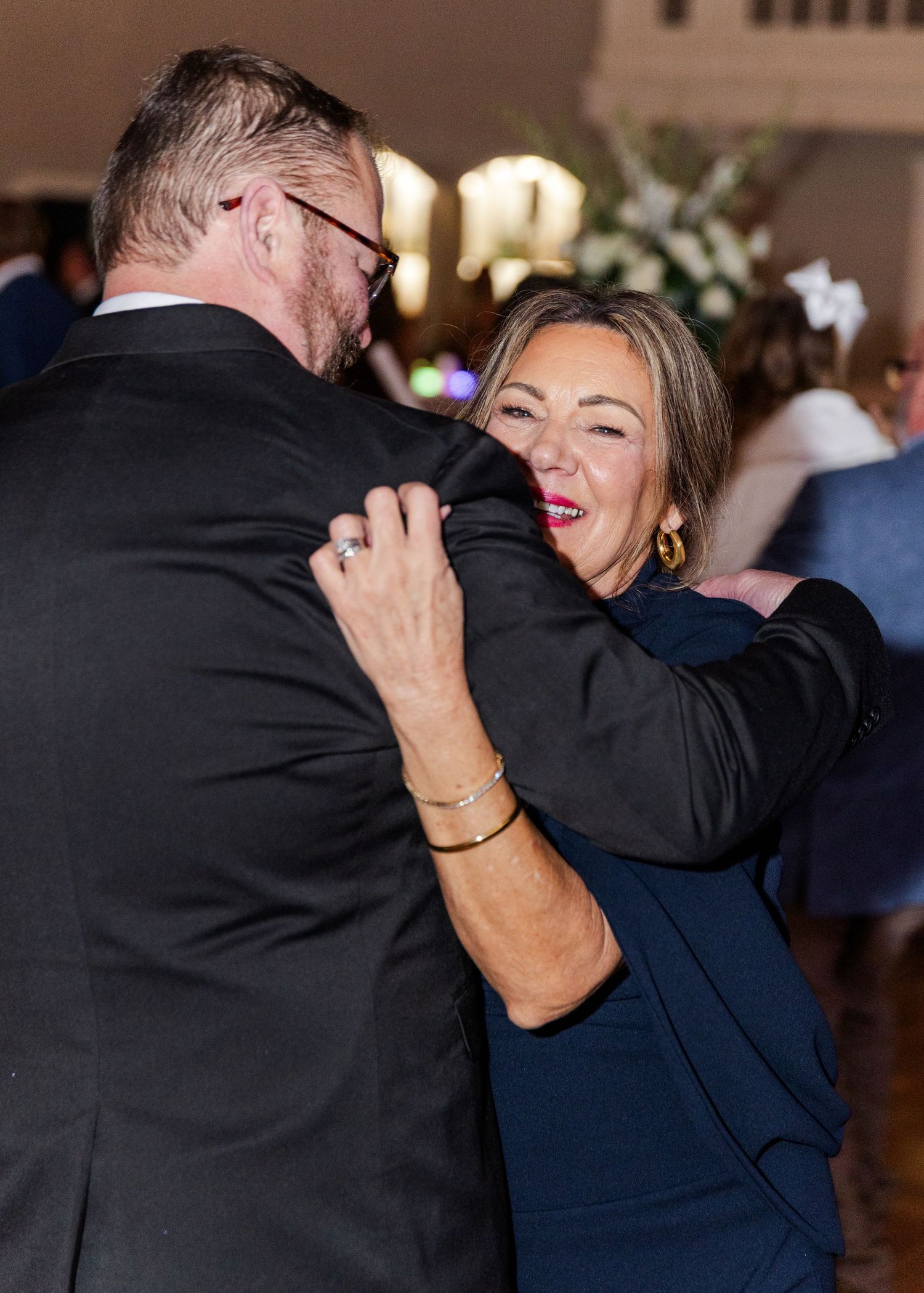 Couple dancing and laughing together at an elegant wedding reception venue.