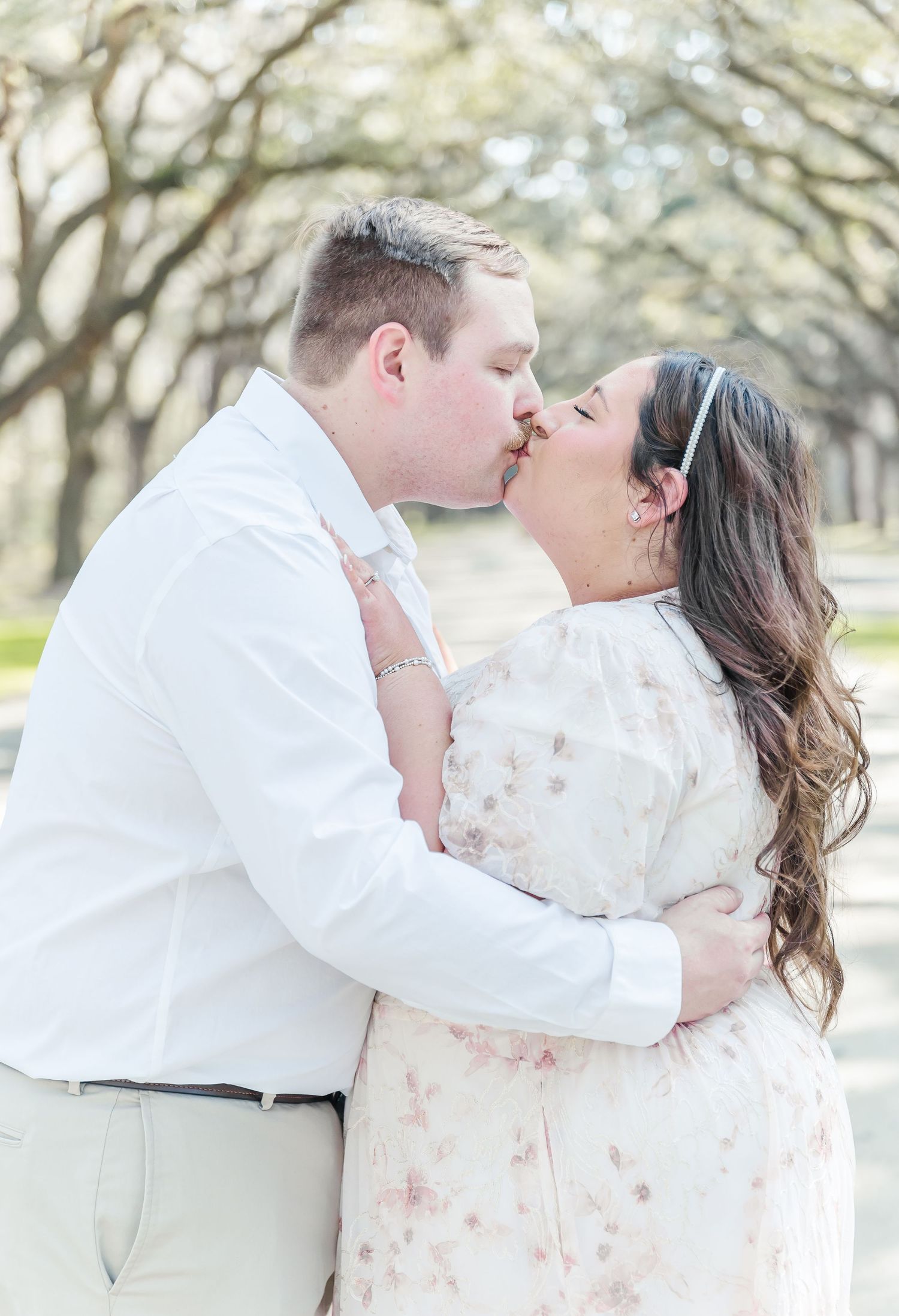 A passionate kiss shared between a couple during their engagement photoshoot.