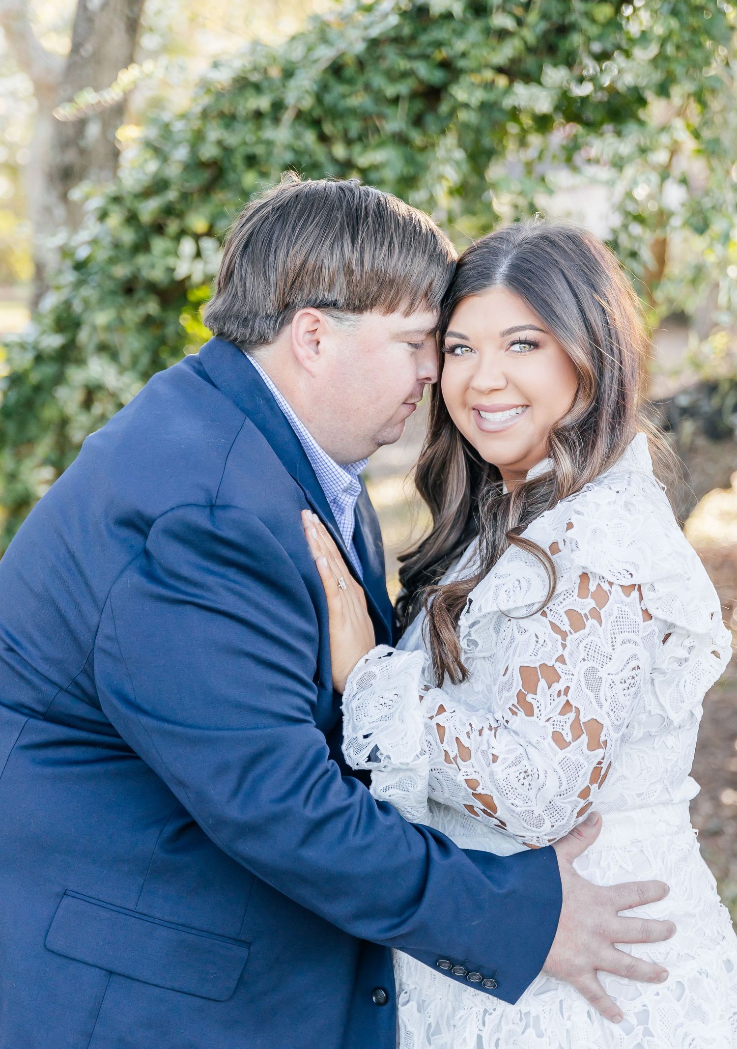 Romantic couple embracing outdoors in formal attire.