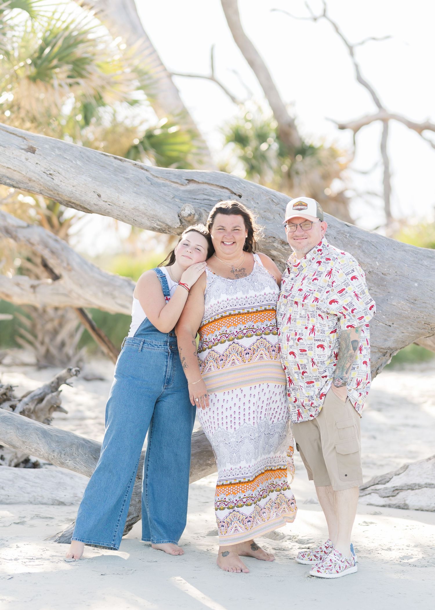 A photo series on a sandy beach shows candid moments of people posing together by a driftwood log.