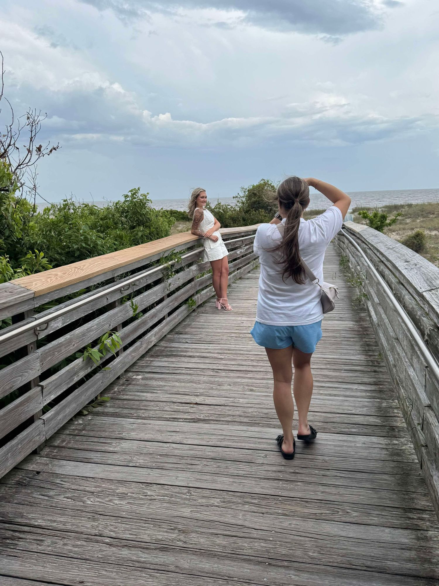 A sequence of photos showing someone walking down a wooden boardwalk path leading through a coastal landscape.