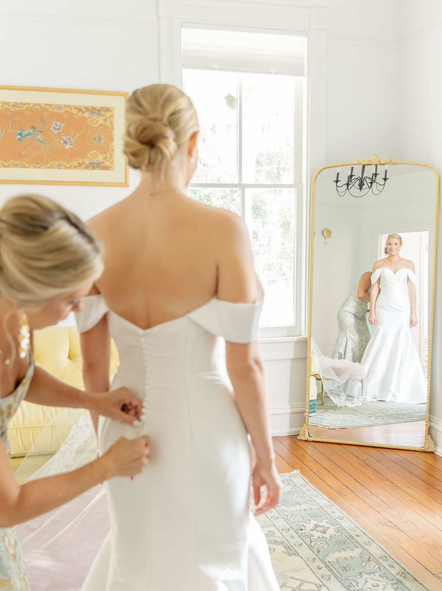 Sunlit bridal preparation room with mirrors and yellow accents.