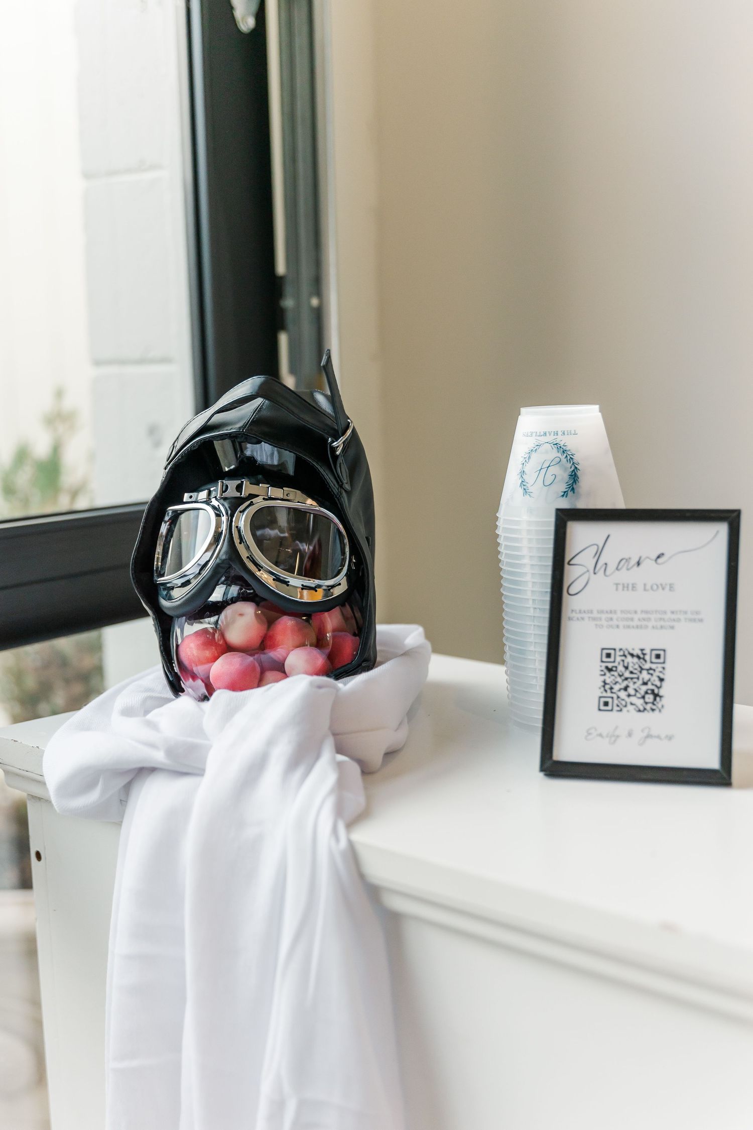 Wedding decor display with Batman masks and QR codes on white windowsills.