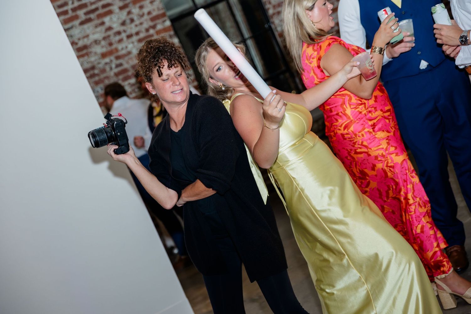 Wedding reception features guests dancing in formal attire including red and yellow dresses.