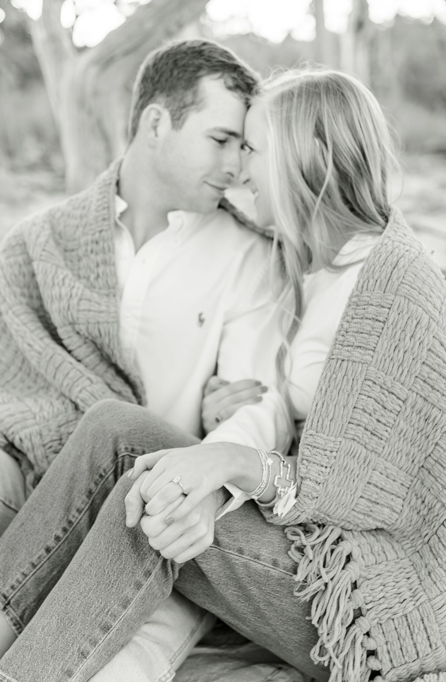 Intimate black and white portrait of a couple sharing a tender moment in a knit sweater.