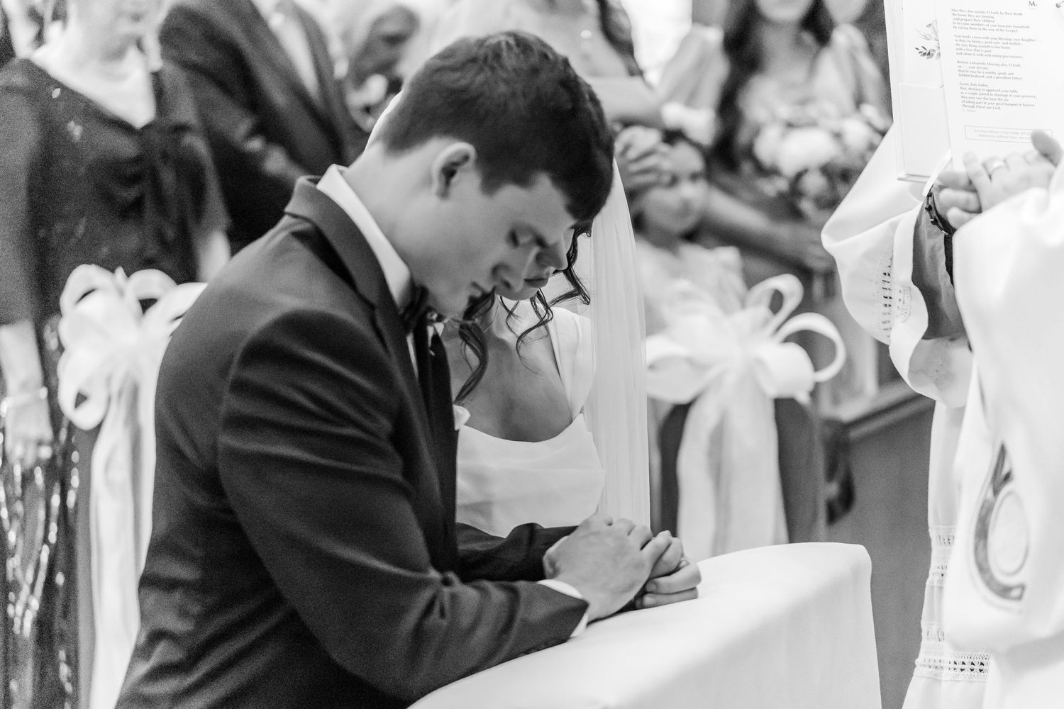 A couple shares an intimate moment while signing their marriage license at a wedding ceremony.