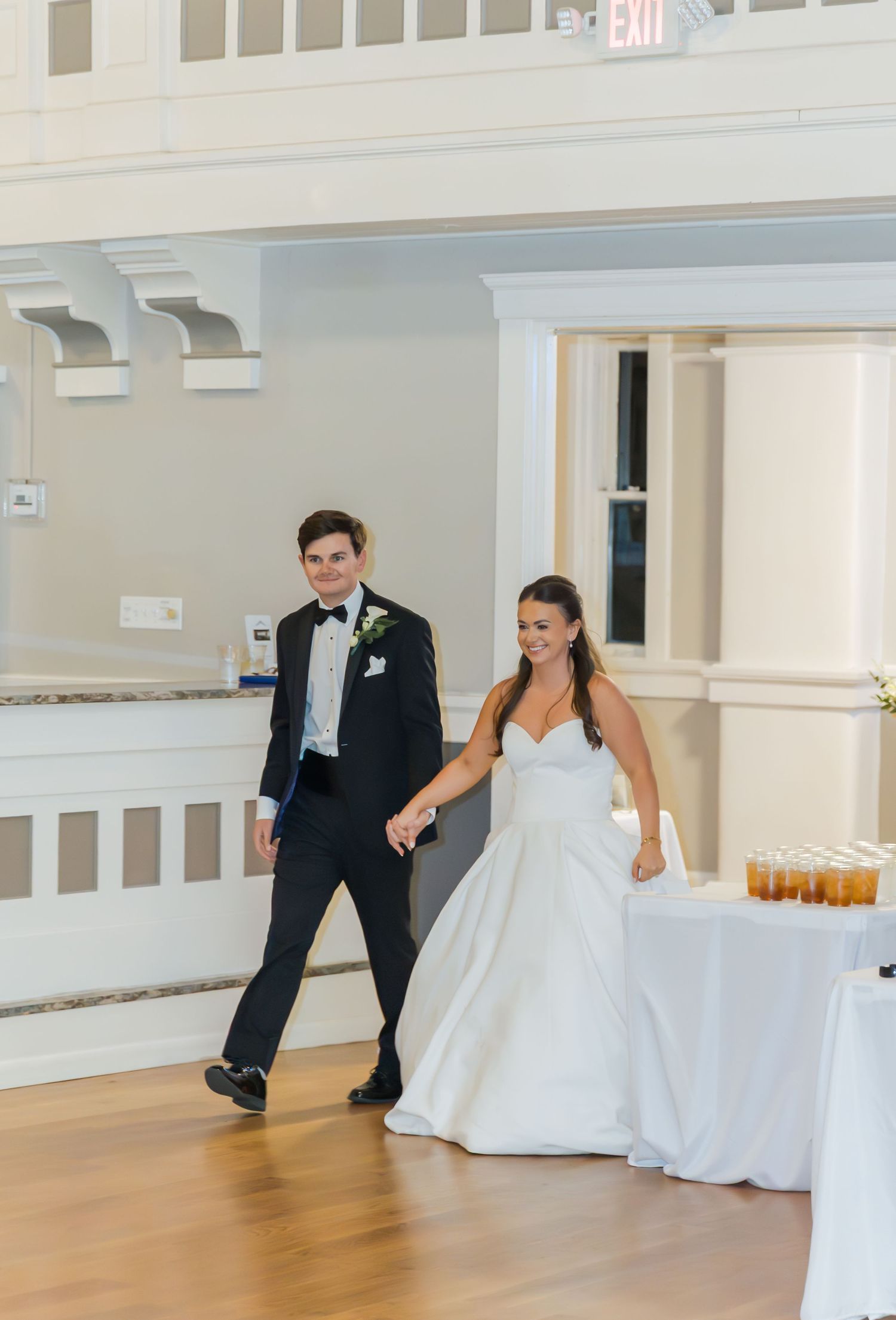 A sequence of four photos showing a couple performing their first dance at a wedding reception in a bright venue.