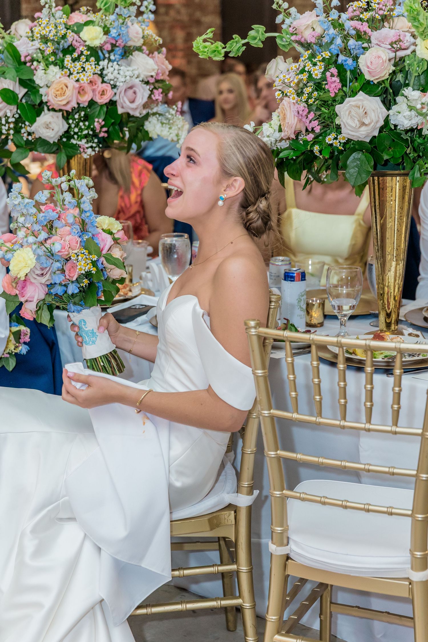 Elegant wedding reception table decorated with lush pink and white floral arrangements and gold chiavari chairs.