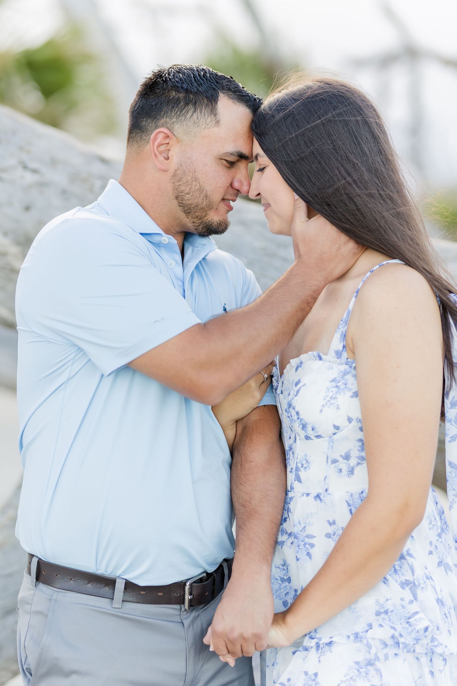 Couple shares intimate romantic moments outdoors wearing coordinating blue and white outfits in a photo series.