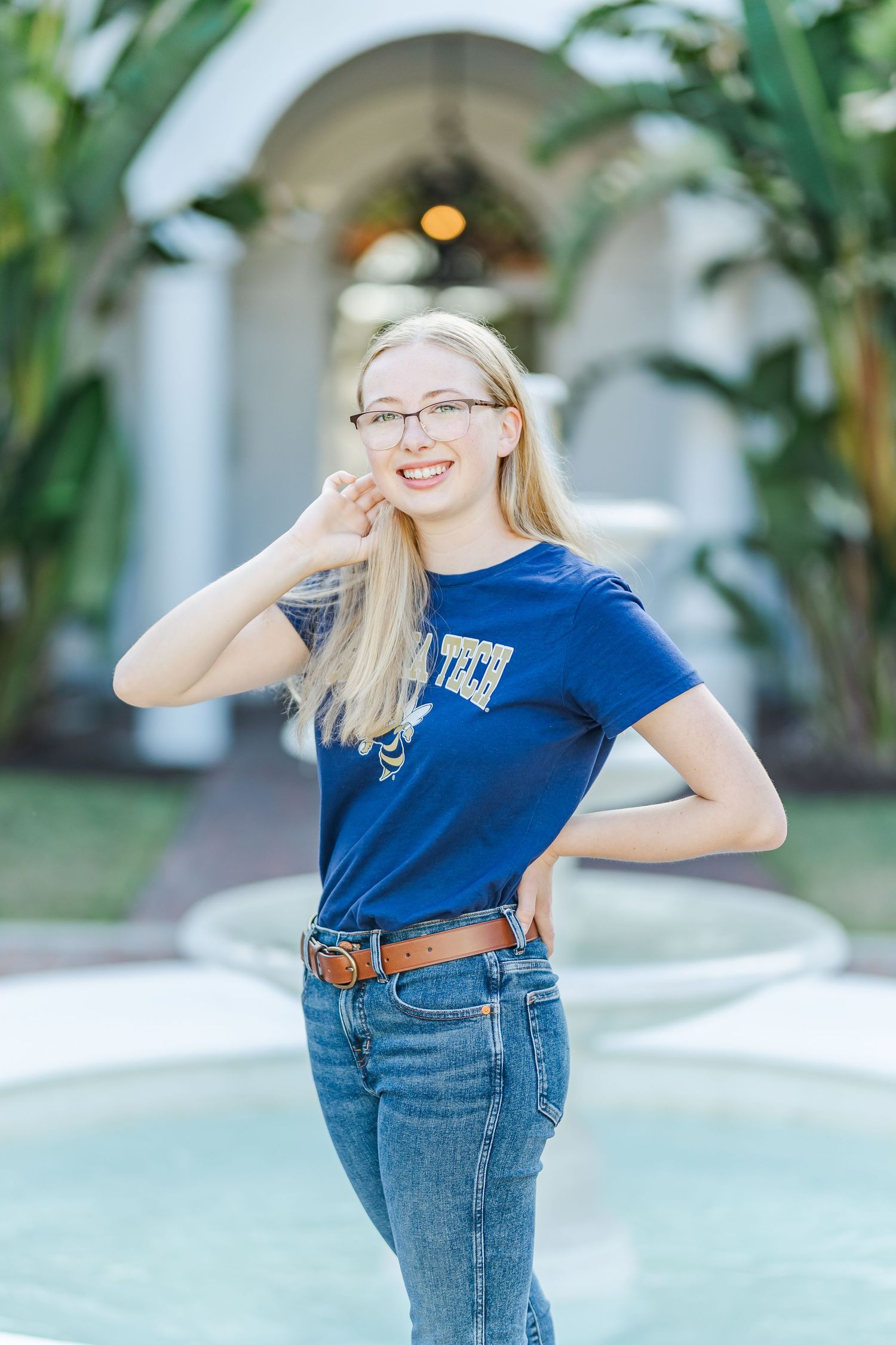 Playful outdoor portraits with green foliage background featuring blue shirt and denim casual style.