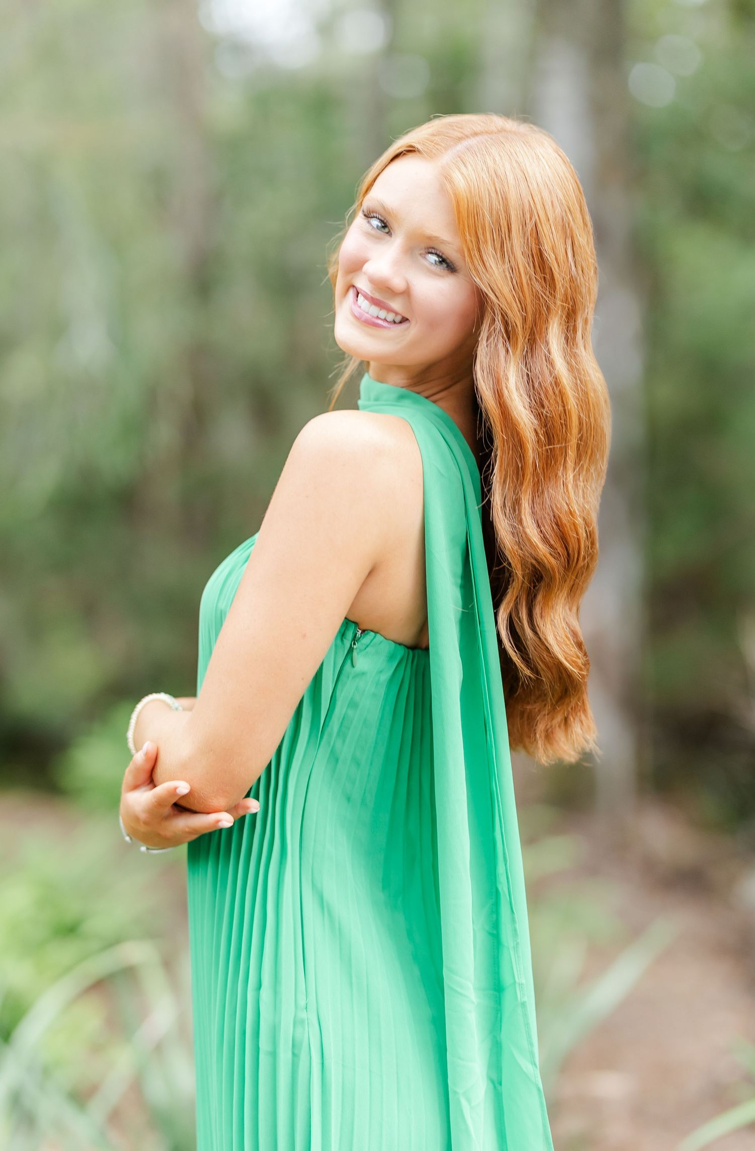 Series of portraits showing a person in a vibrant emerald green dress posing playfully against a blurred forest background.
