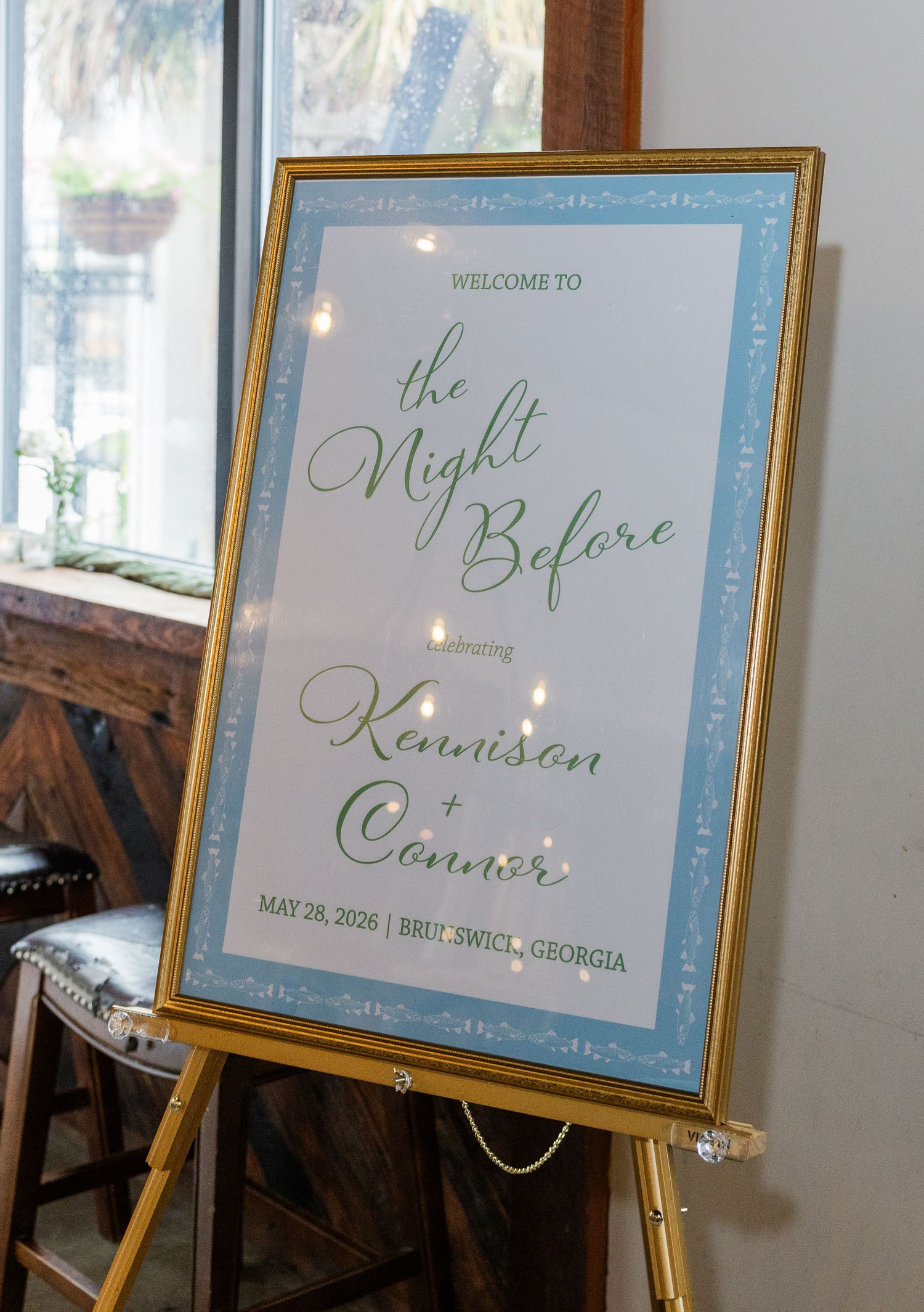 Gold-framed wedding welcome sign for The Night Before rehearsal dinner featuring Kennison and Connor in Brunswick, Georgia.
