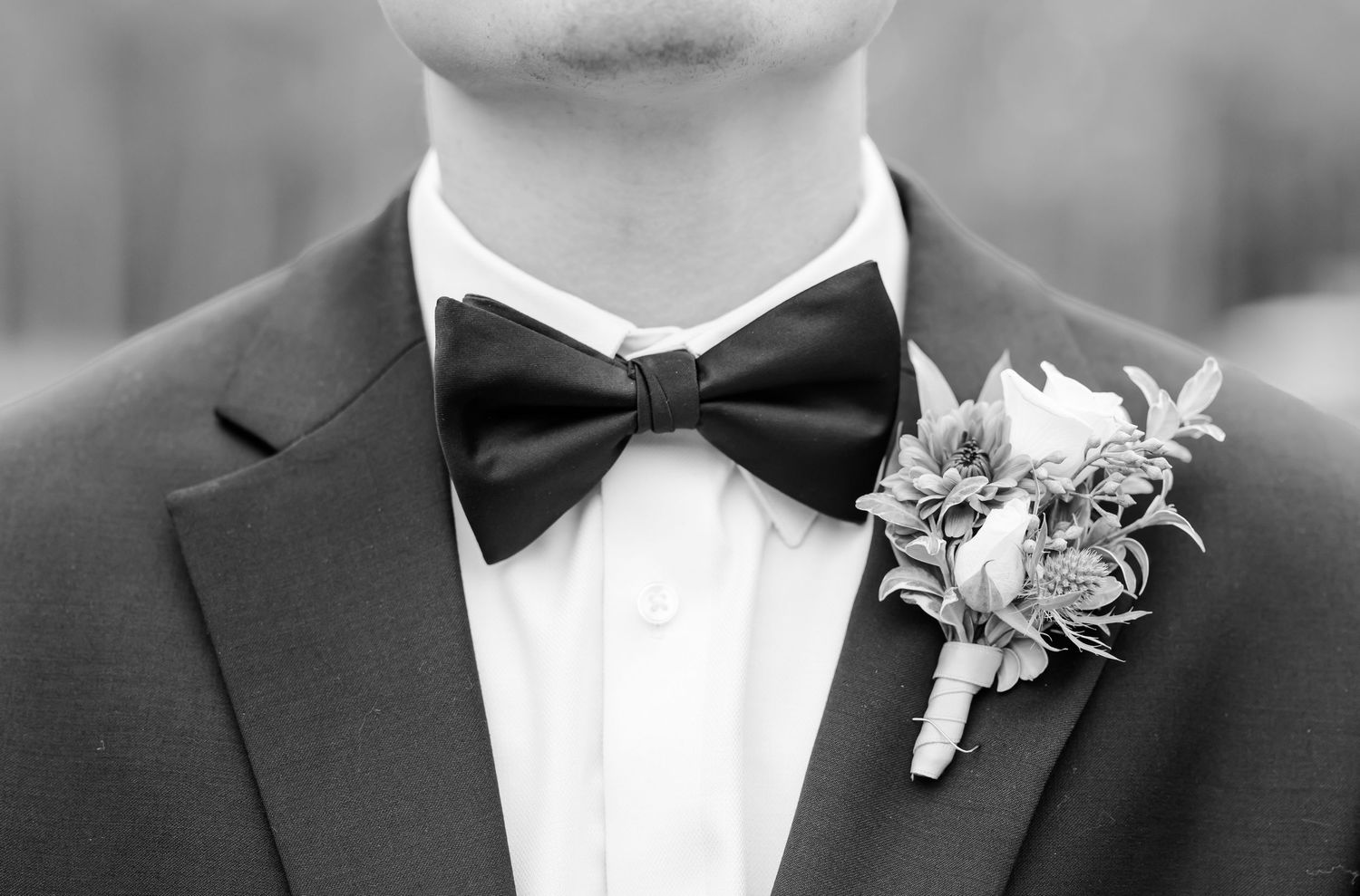 Black and white detail shots of groom's bow tie and boutonniere.