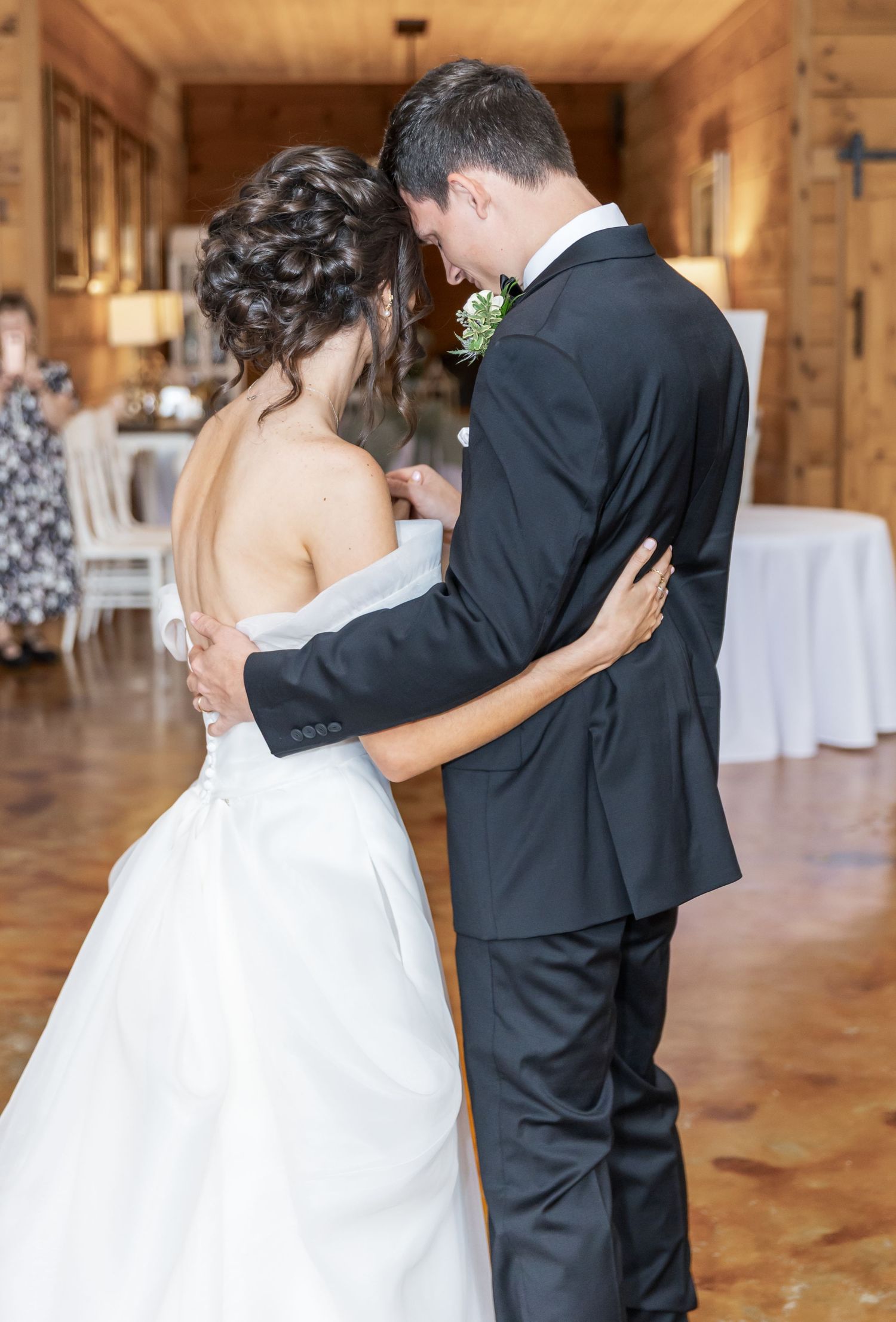 First look moment between bride and groom in a rustic wooden venue with natural lighting.