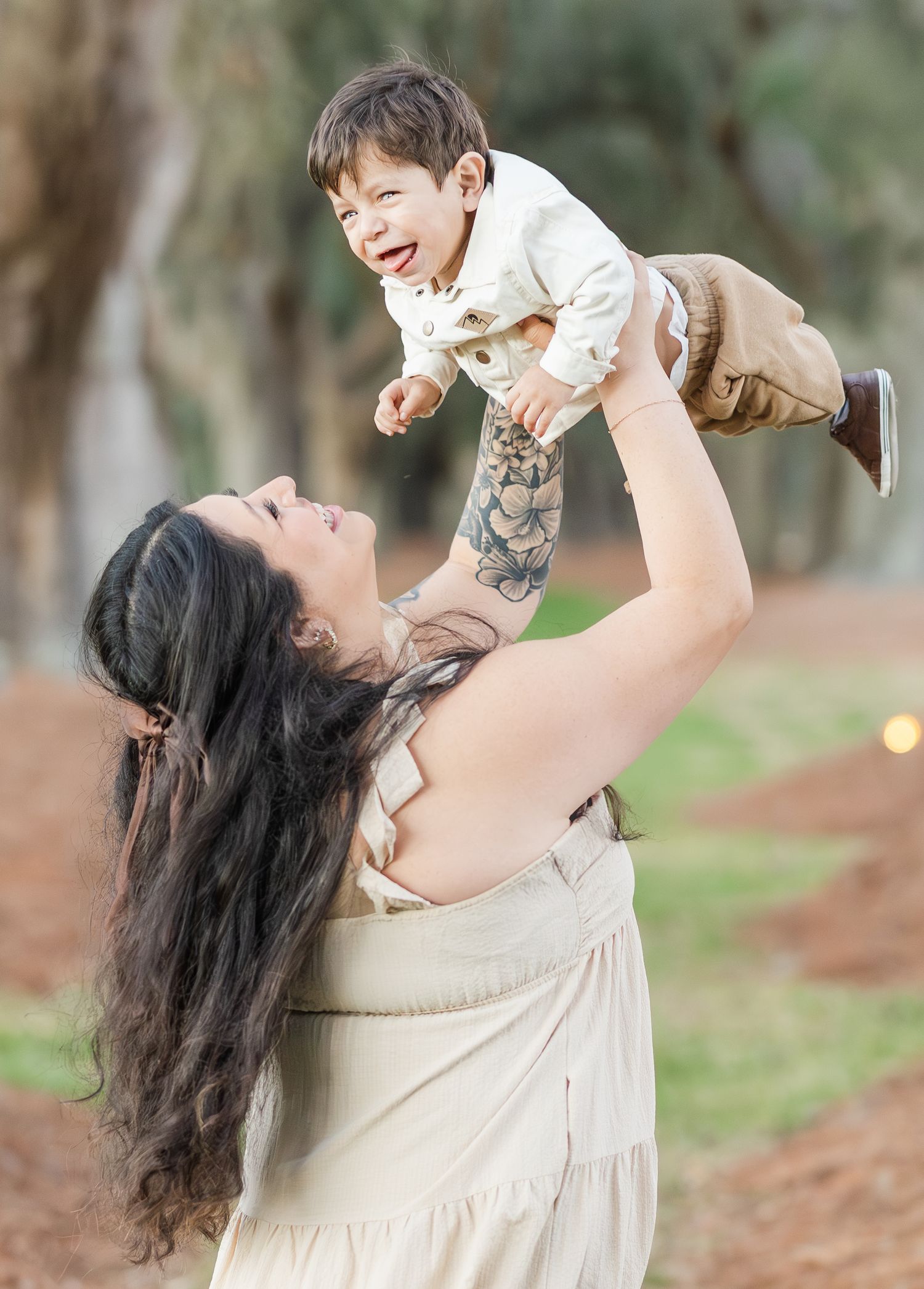 Playful outdoor family photoshoot with joyful interactions against natural background.