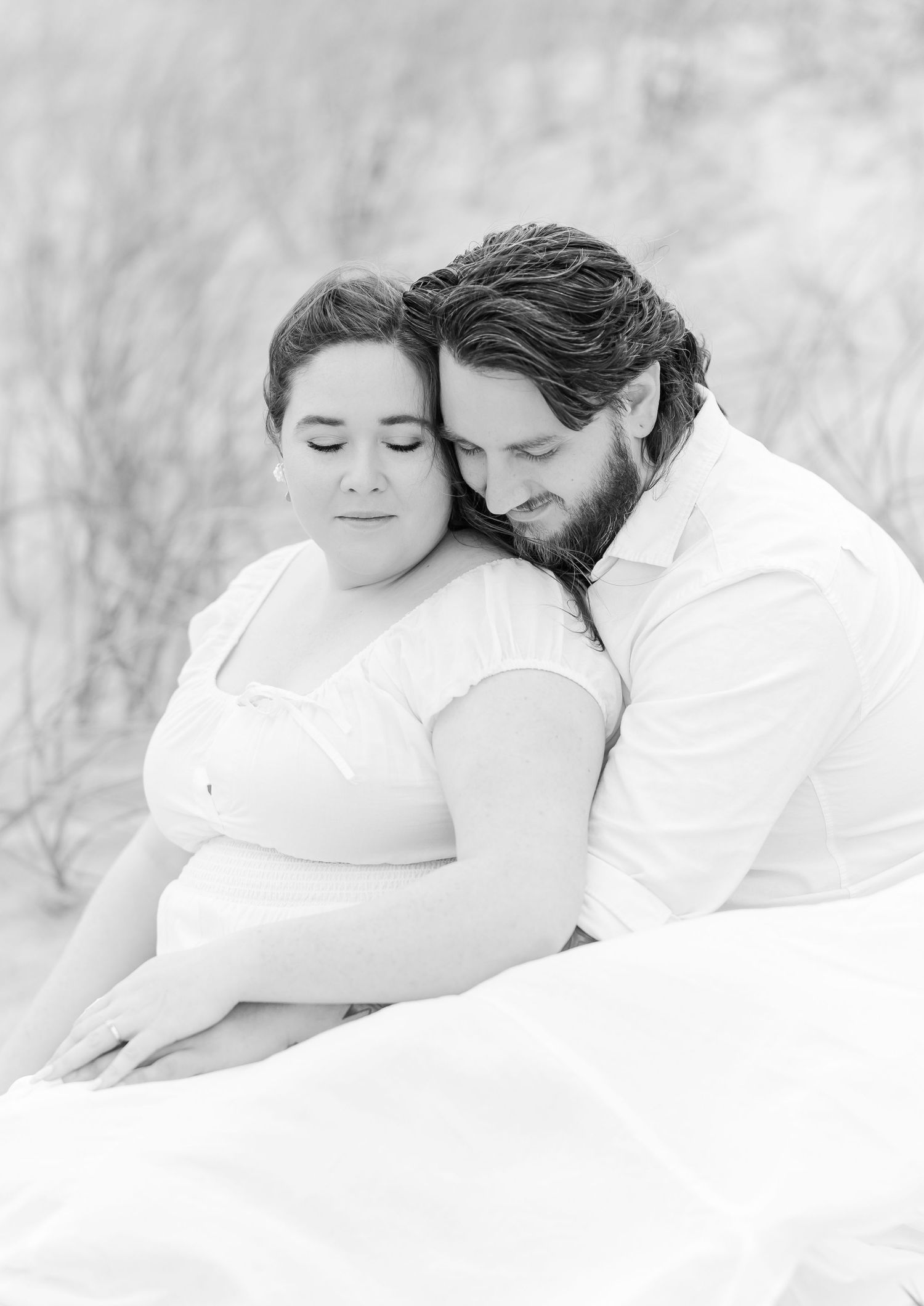 Intimate black and white portrait of a couple sharing a tender moment.