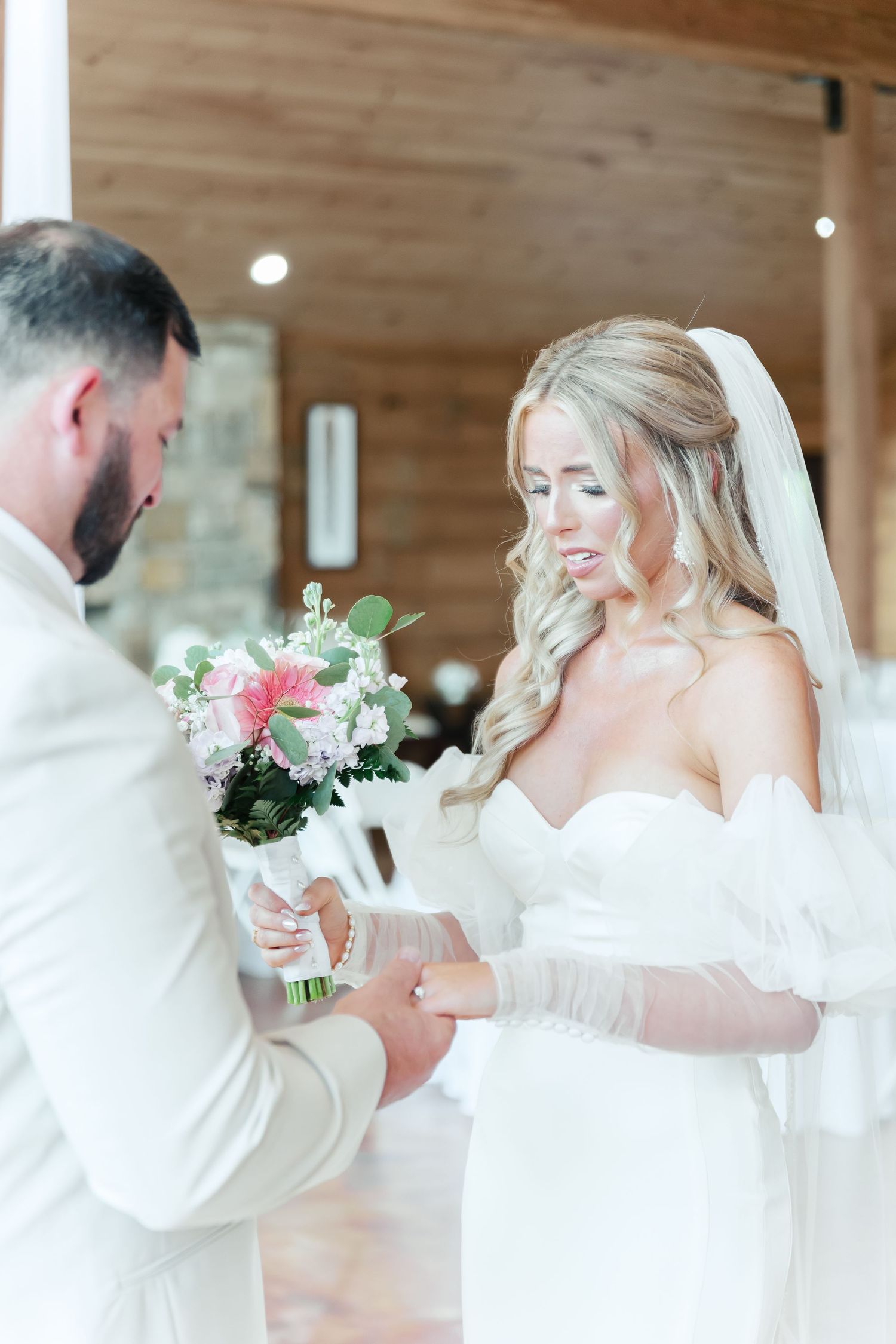 An intimate moment during a wedding ceremony with floral bouquet exchange.