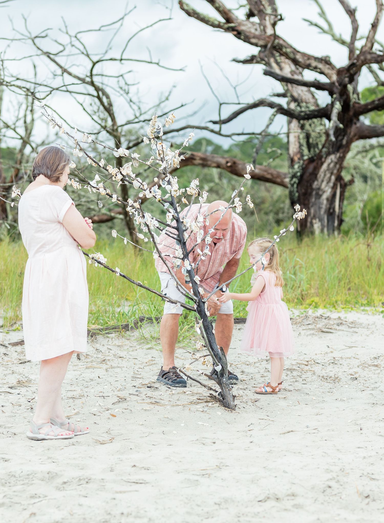 People in pastel outfits take turns swinging at a romantic cherry blossom orchard during sunset.