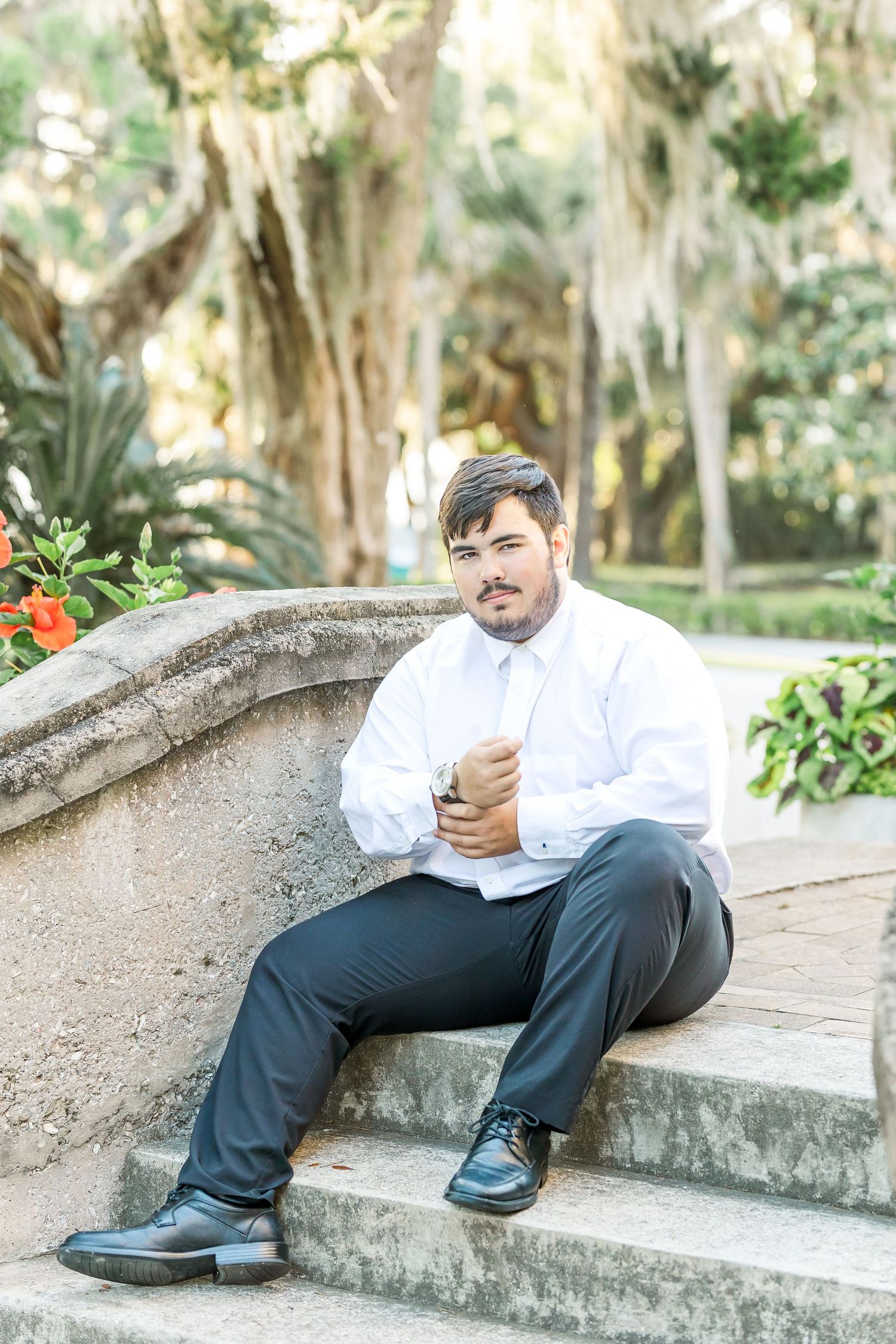 Multiple angles of someone seated on outdoor stone steps surrounded by Spanish moss and tropical foliage.