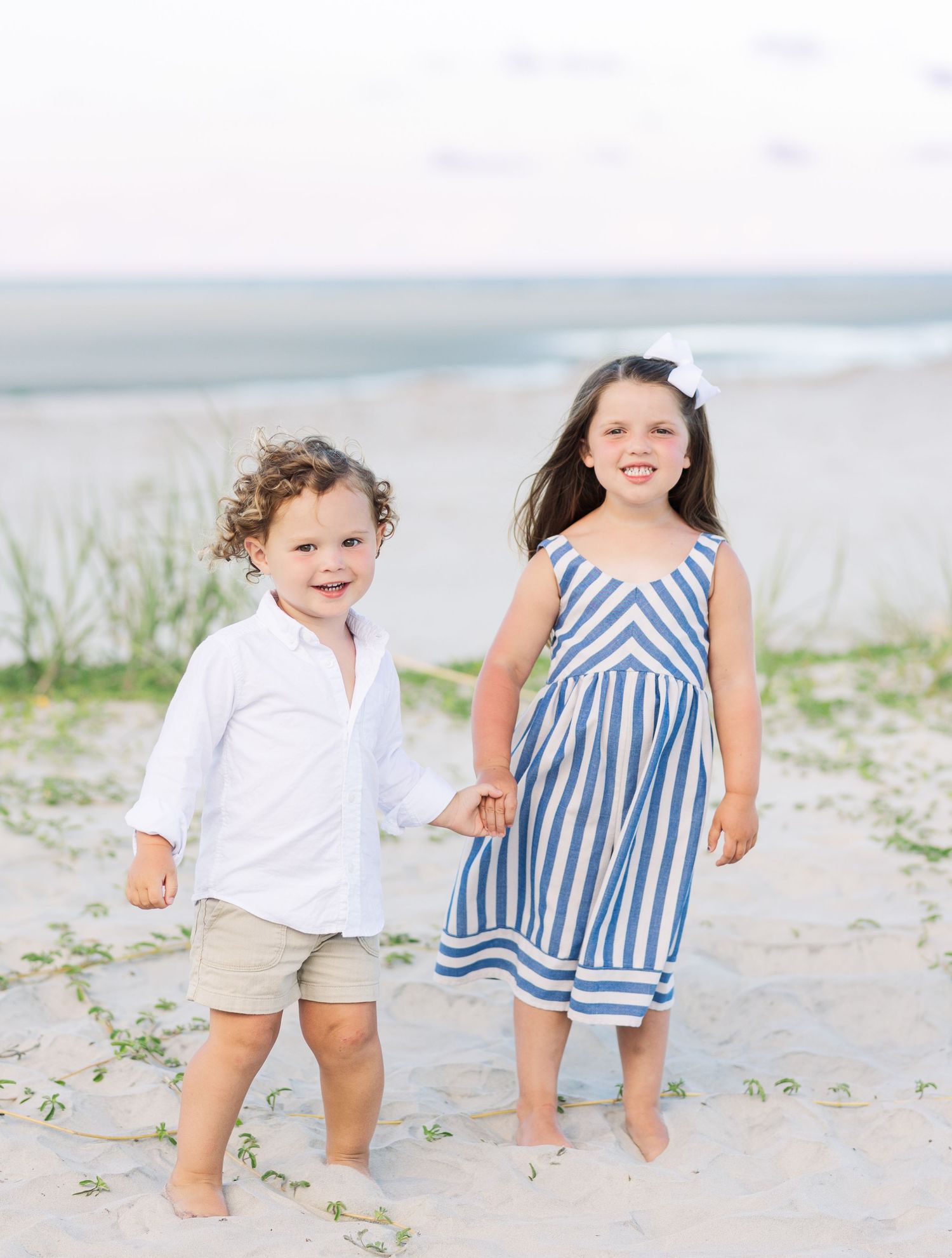 A group of candid beachwear photos shows two people playing in the sand wearing coordinated blue and white outfits.