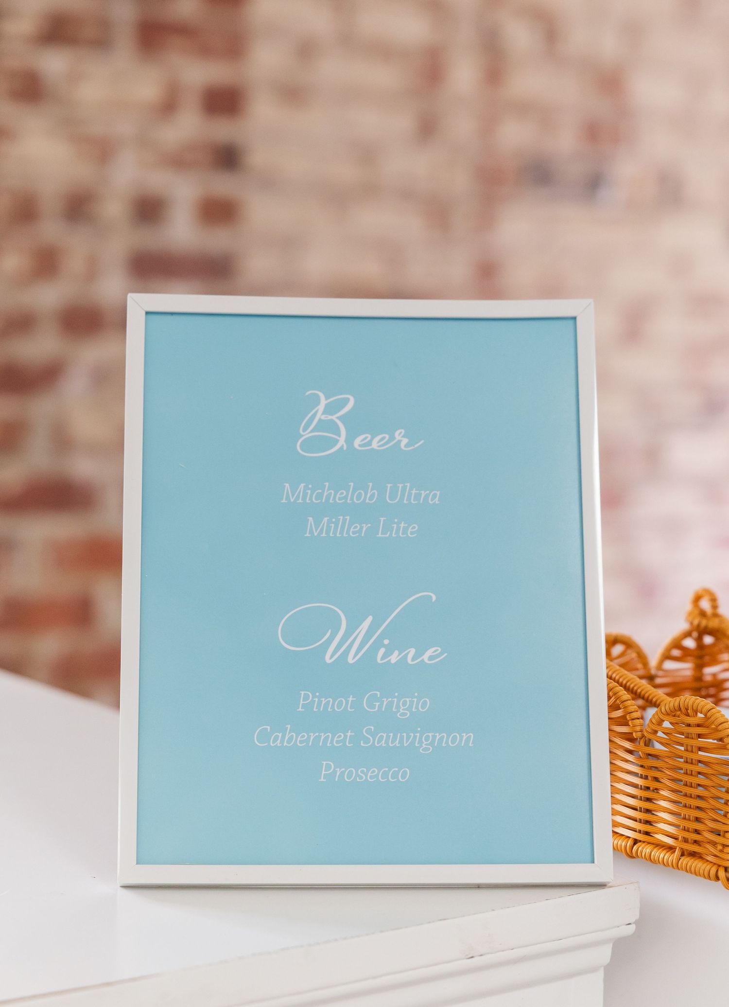 Blue framed wedding bar menu sign listing beer and wine options including Michelob Ultra, Miller Lite, Pinot Grigio, and Prosecco.
