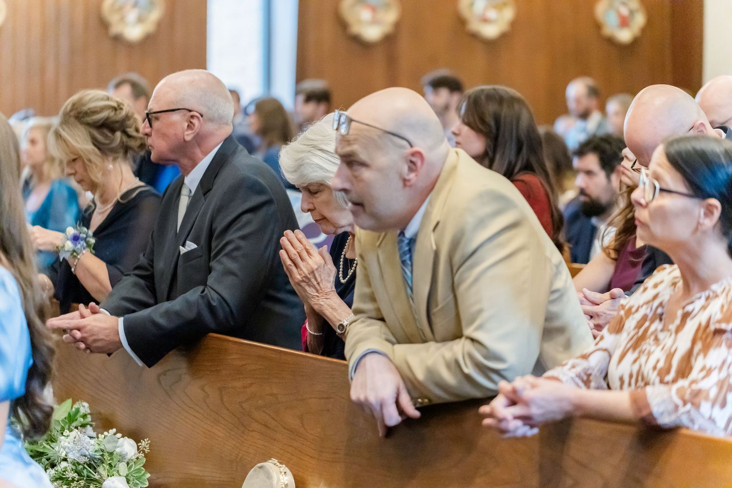 Wedding guests seated in church pews during a ceremony.