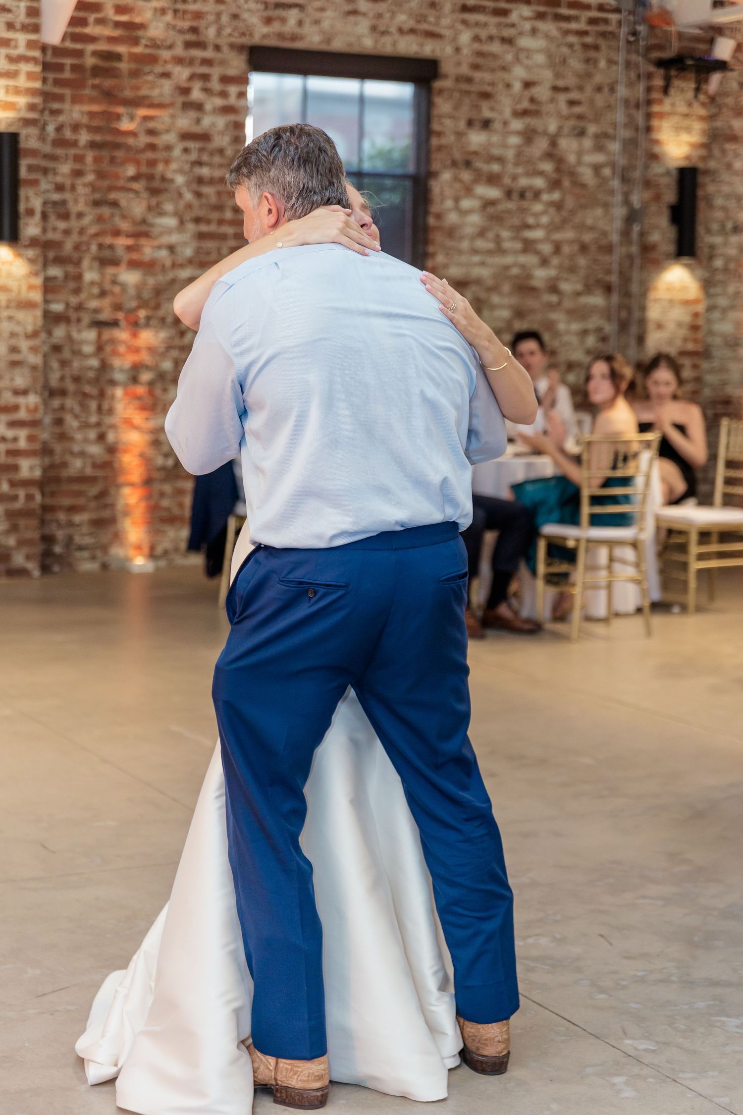 A sequence of dance steps shown in an exposed brick event venue with warm lighting and rustic decor.