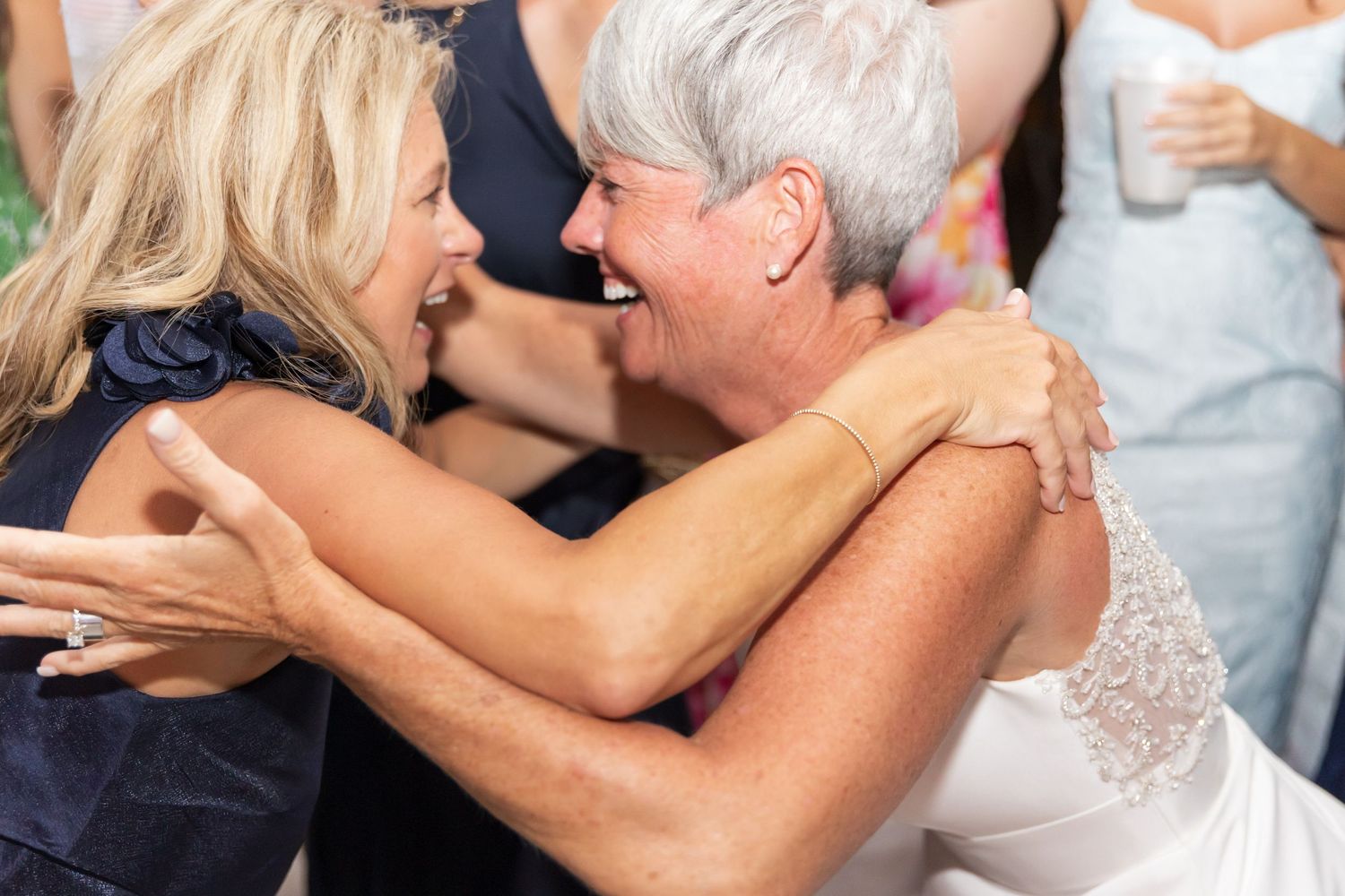 Two people share a joyful embrace while dancing at a celebration.