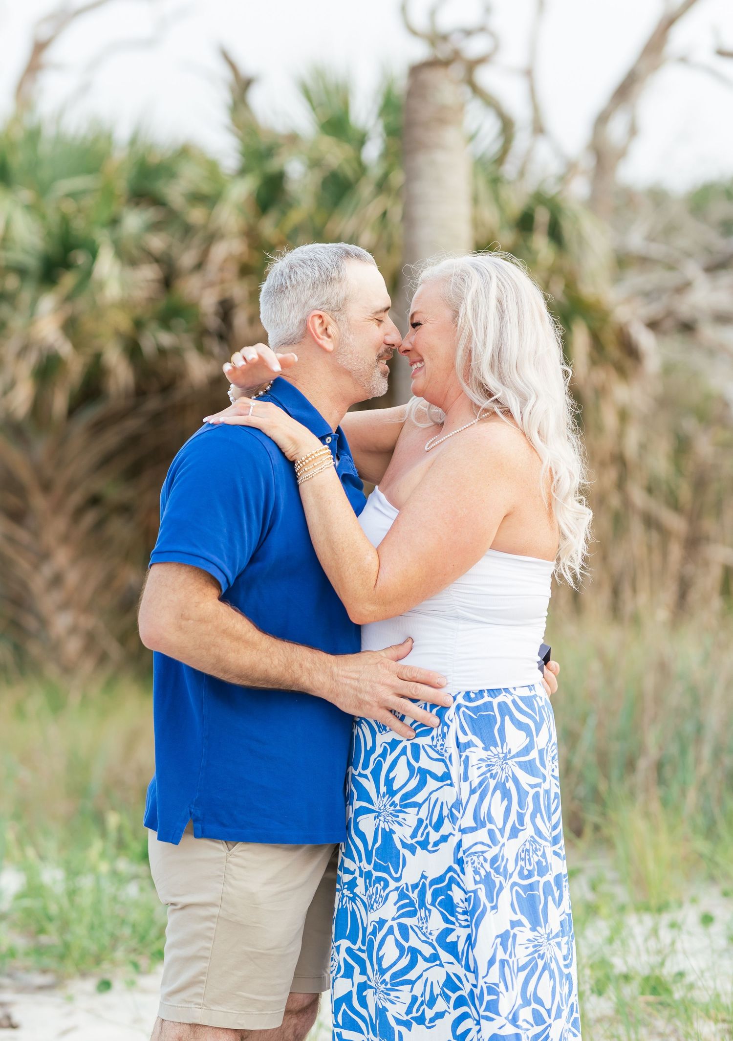 A romantic embrace between a couple wearing coordinating blue and white outfits.