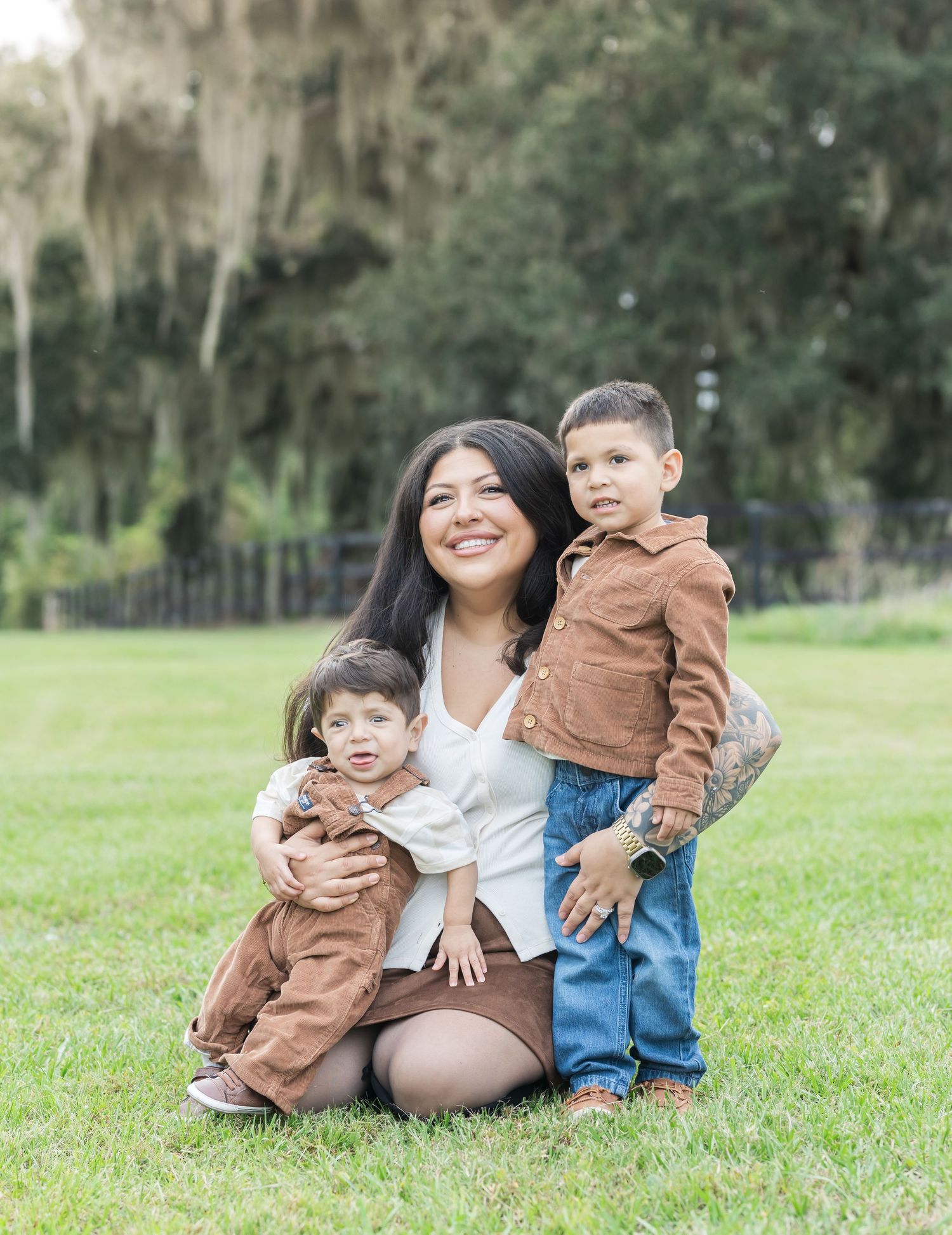 Family relaxing together on grassy lawn in outdoor setting with natural lighting.
