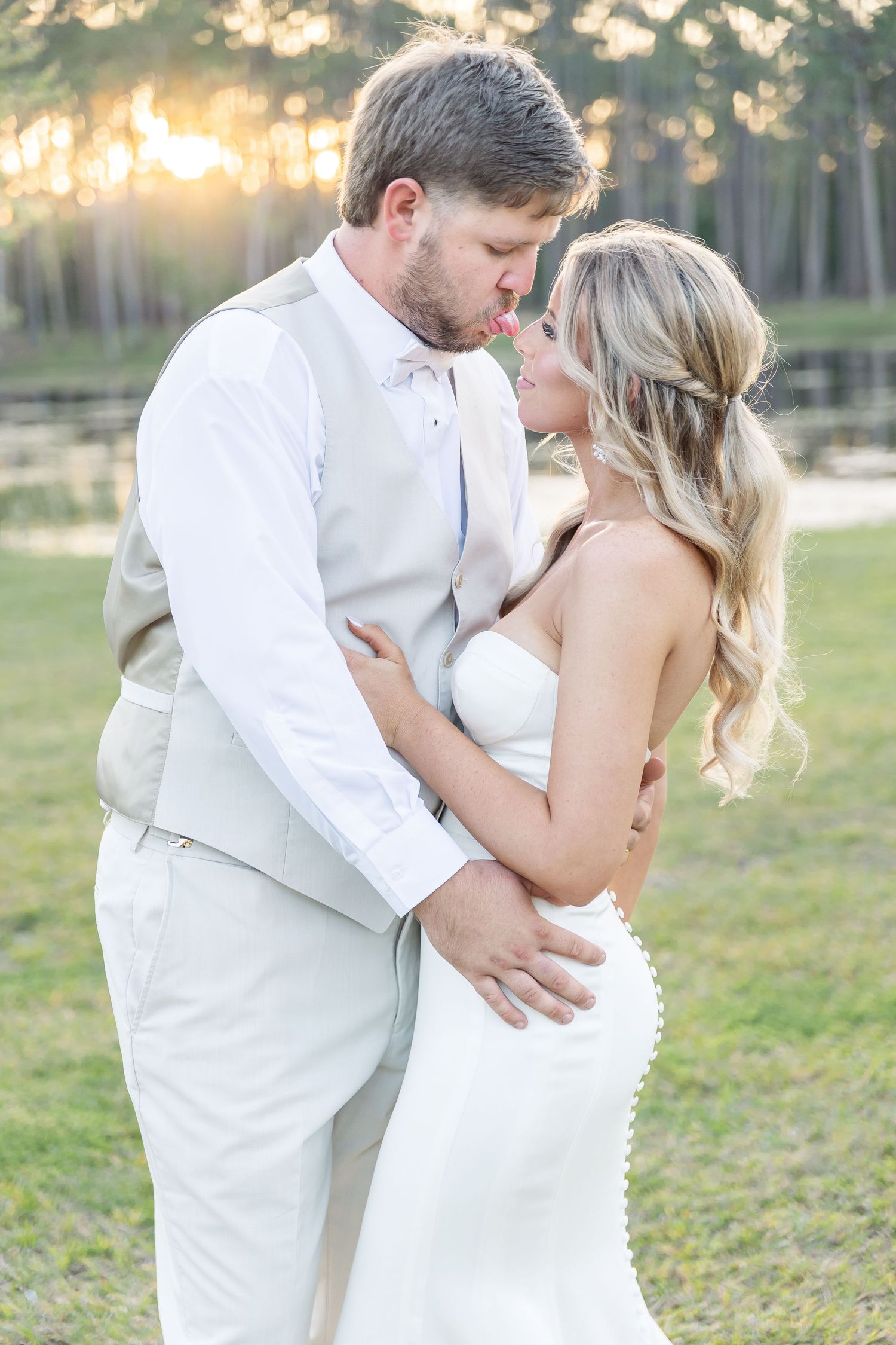 Intimate wedding portrait at golden hour with couple embracing by a tranquil lake.