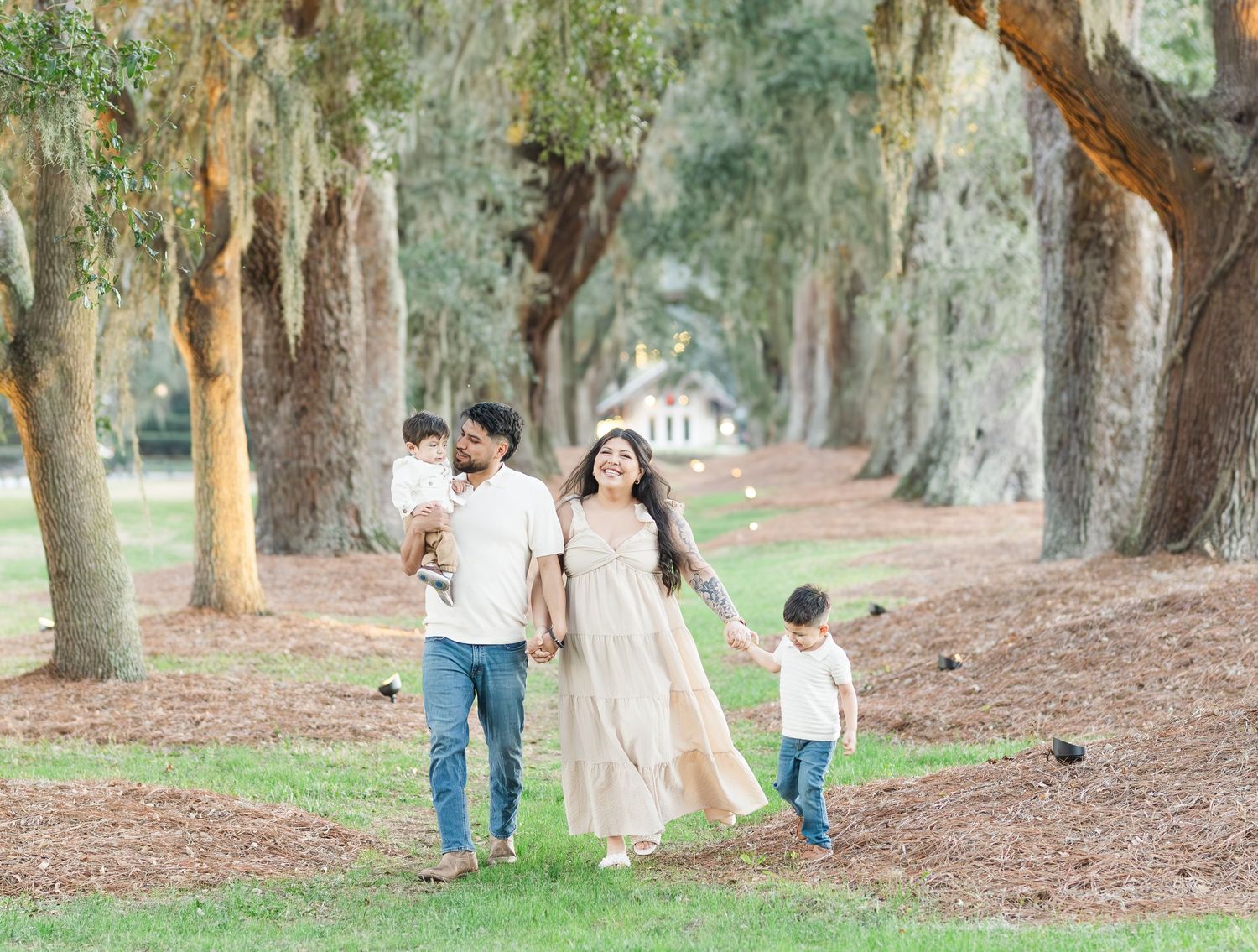 Family walking together along a tree-lined path in a peaceful park setting.