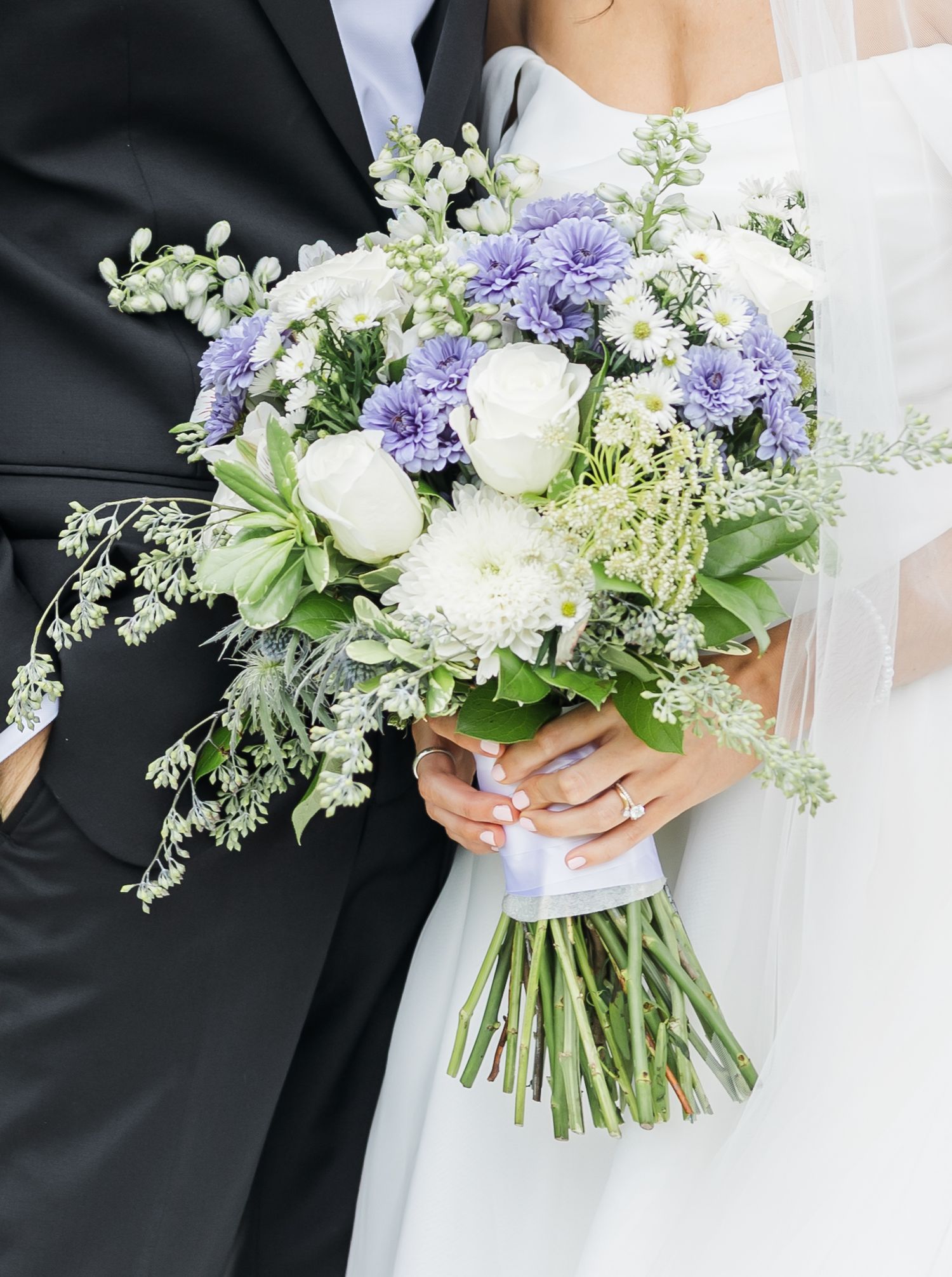 Close-up detail shots of elegant white and purple wedding bouquets with mixed flowers against dark and light backgrounds.
