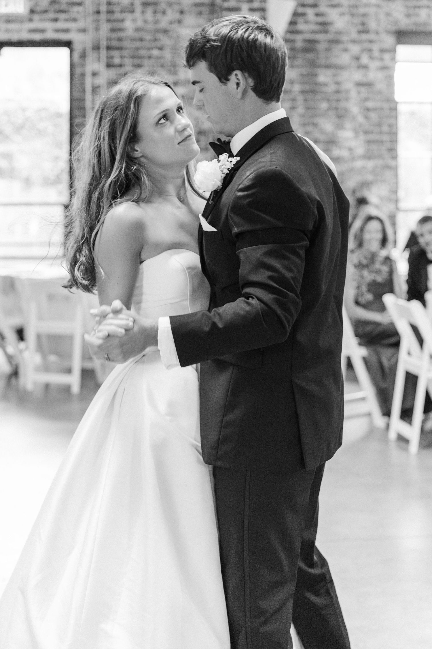 Bride and groom share an intimate first dance in black and white wedding photo.
