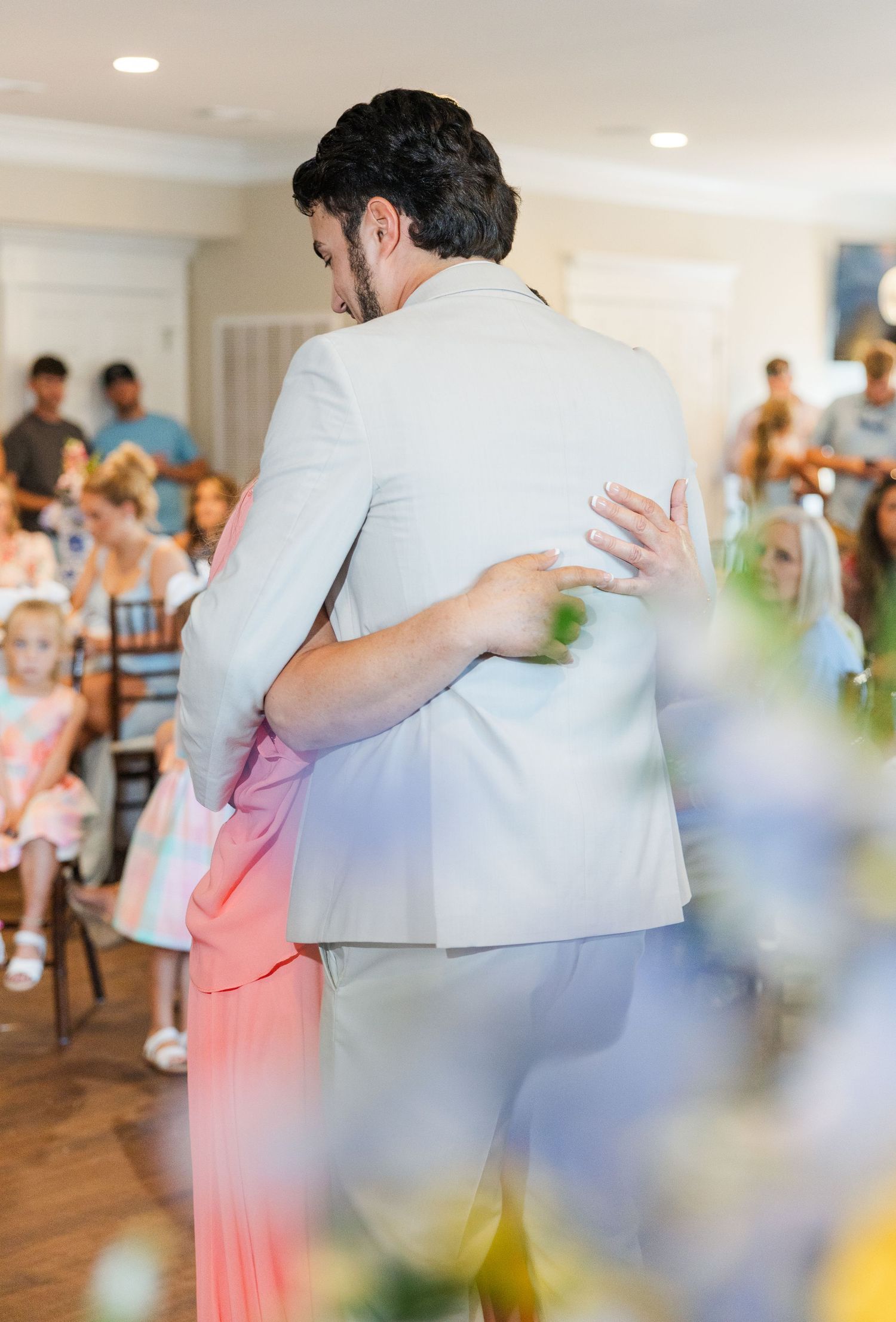 Groom and mother share a close embrace during the mother-son dance at the wedding reception.