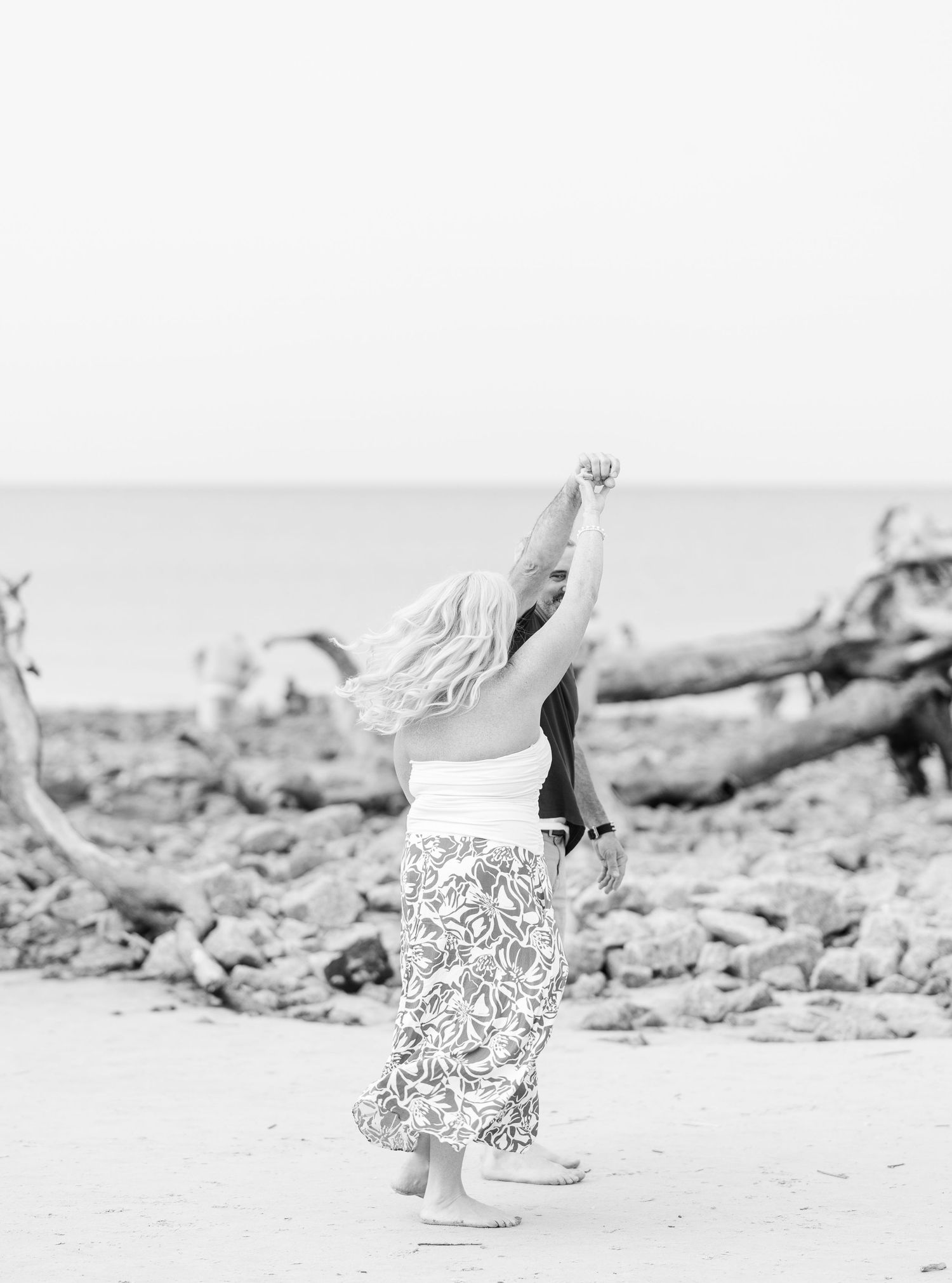 Black and white sequence showing child playing and running on beach with driftwood.