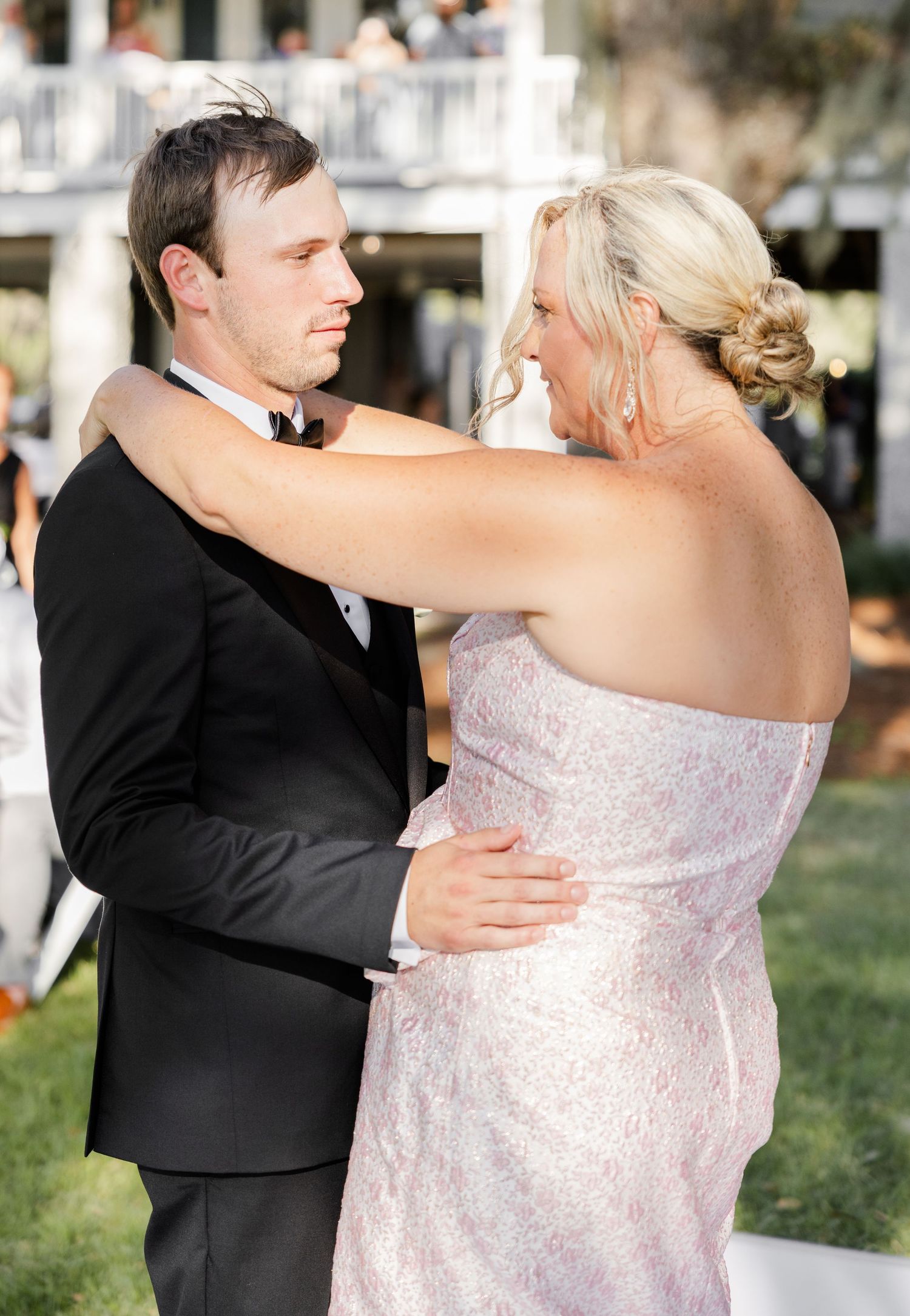Bride and groom share a tender first dance moment outdoors at their wedding reception.