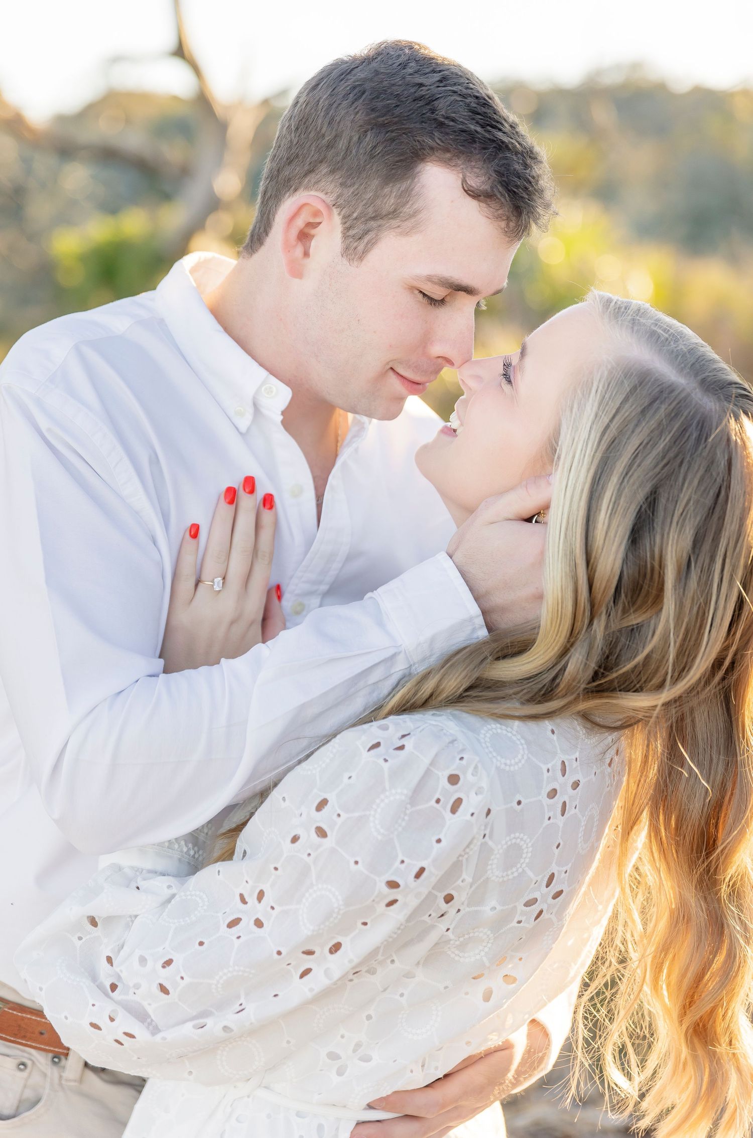 A romantic outdoor photo showing a tender embrace against a sunset backdrop.