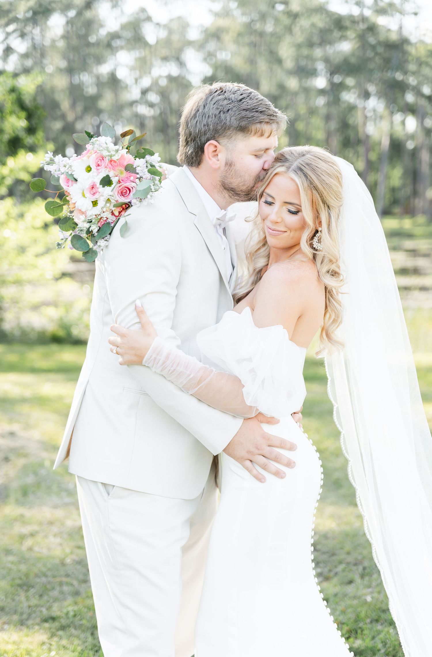 Newlyweds share an intimate moment during their outdoor wedding photoshoot.