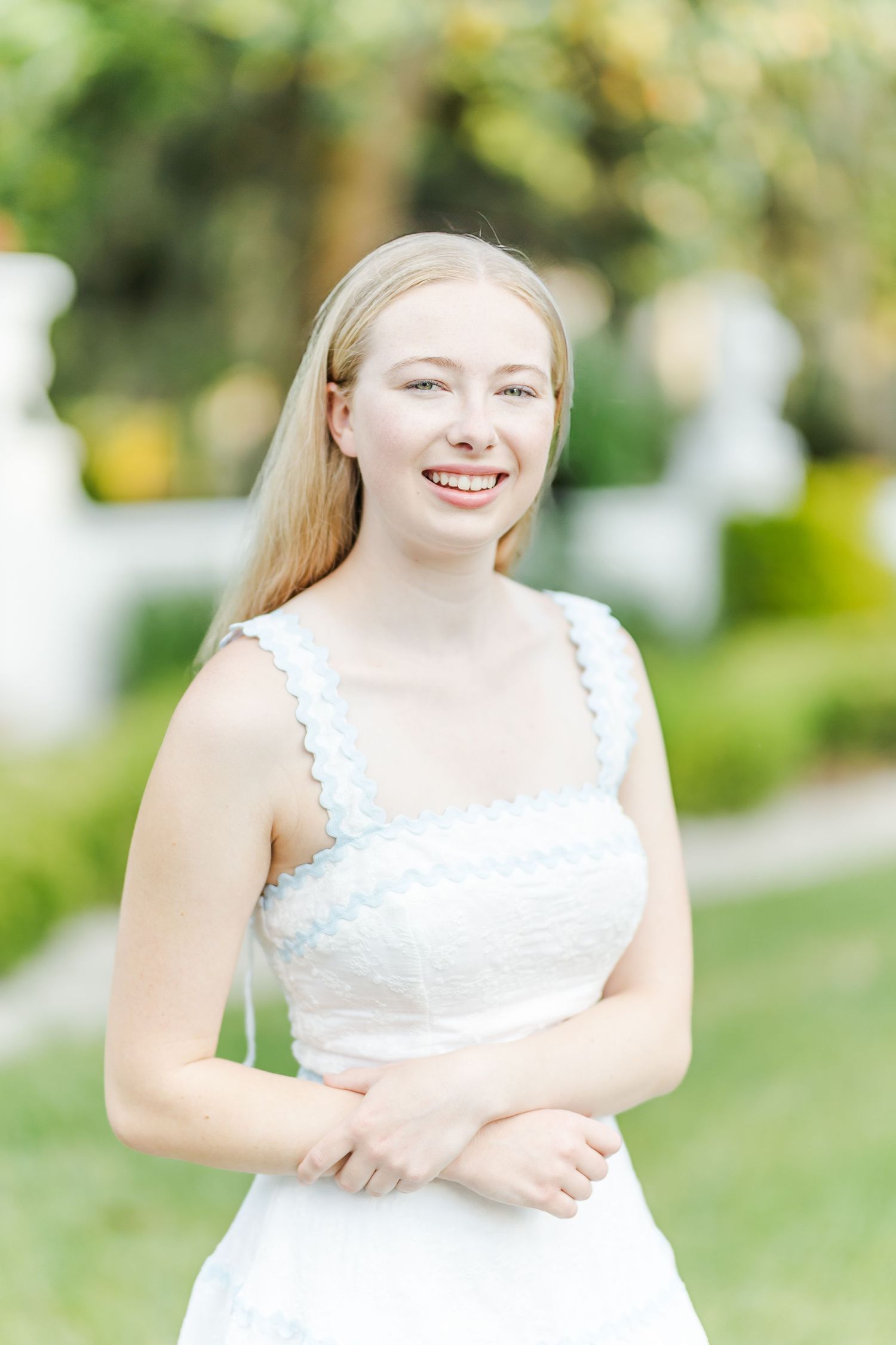 Outdoor portrait series in white lace dress with natural garden backdrop and soft lighting.