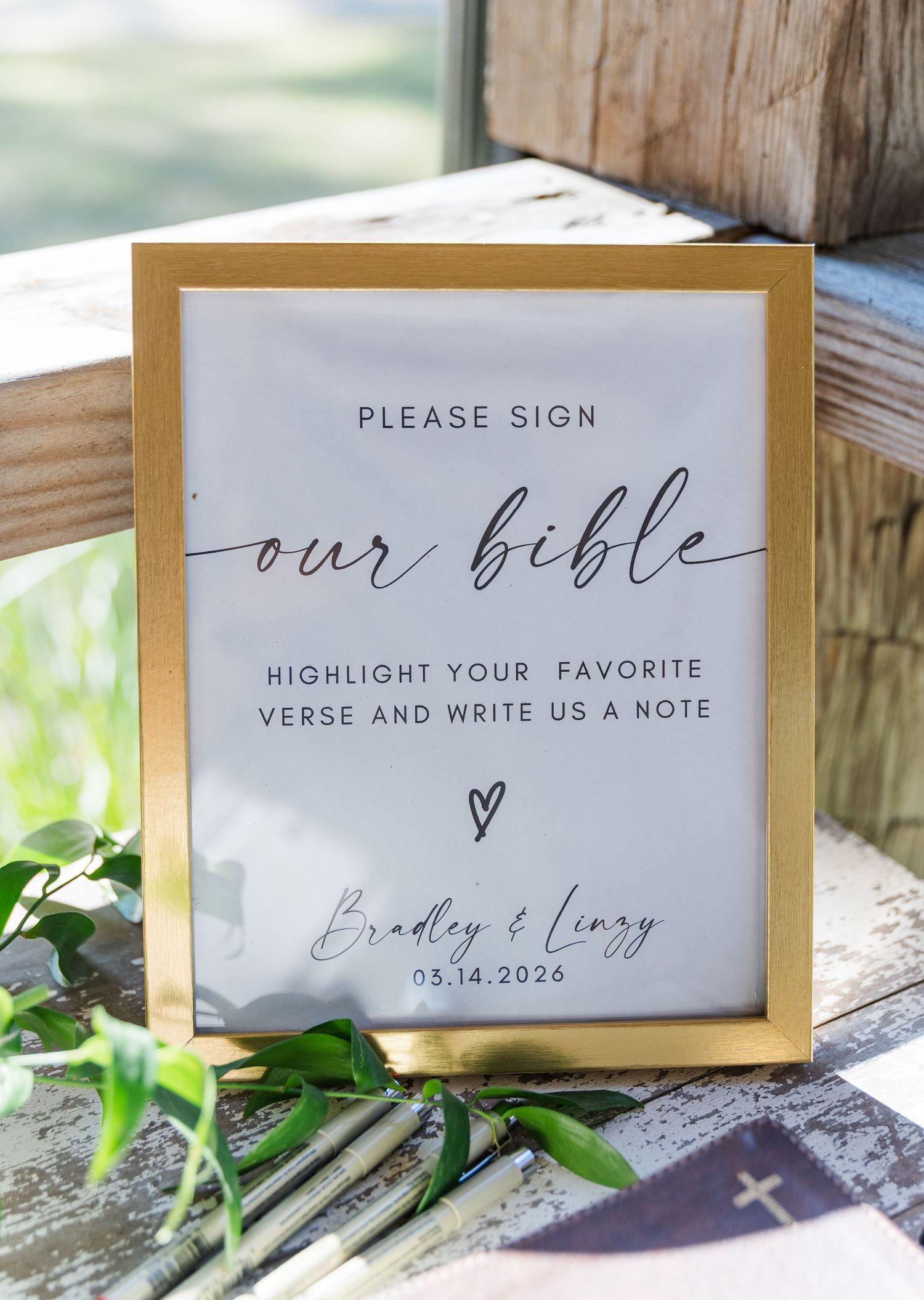 Gold framed wedding sign asking guests to sign the Bible for Bradley and Lizzy on 05.14.2024.