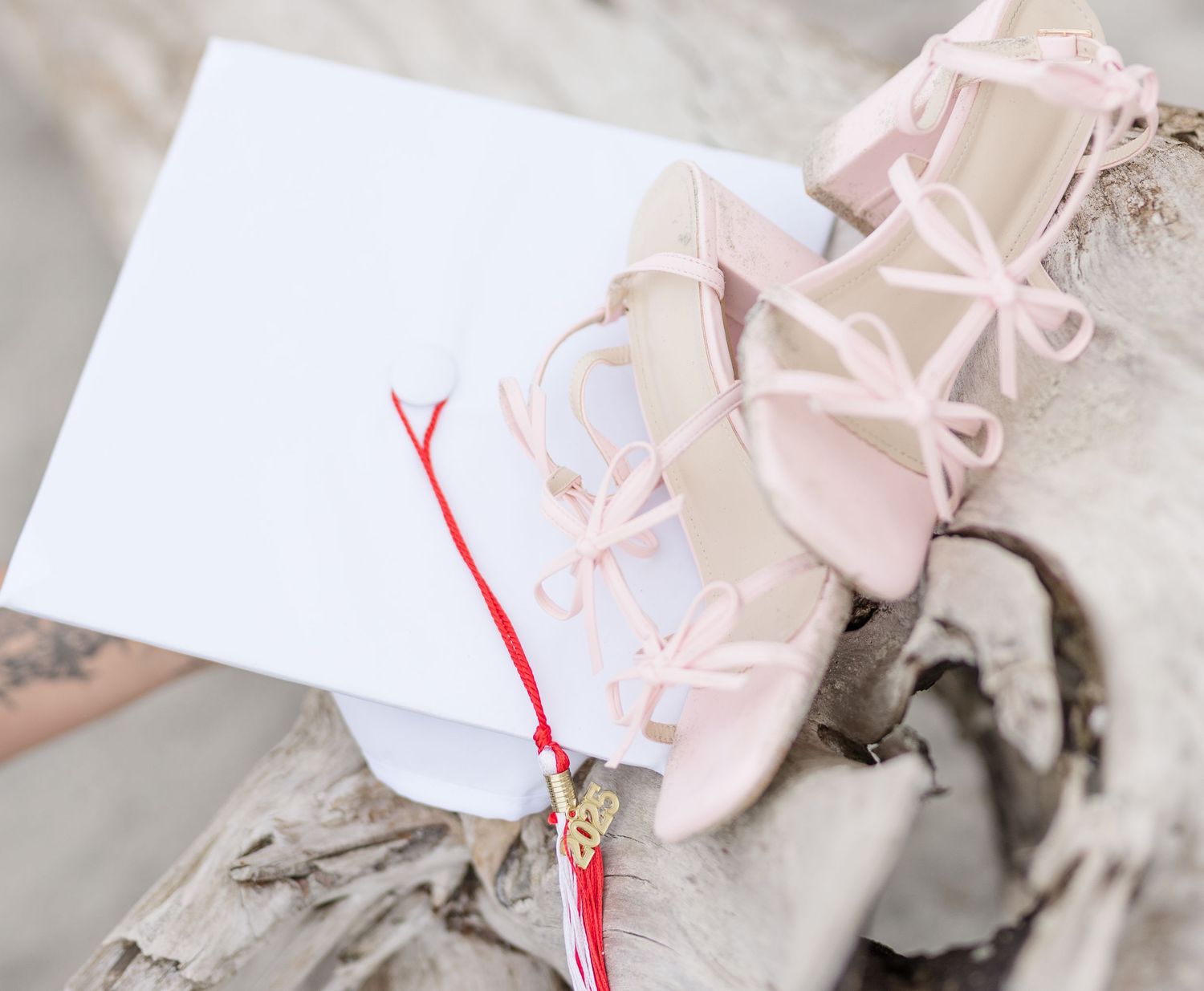 A series of pink ballet pointe shoes arranged with white paper tags and a red string against a light background.