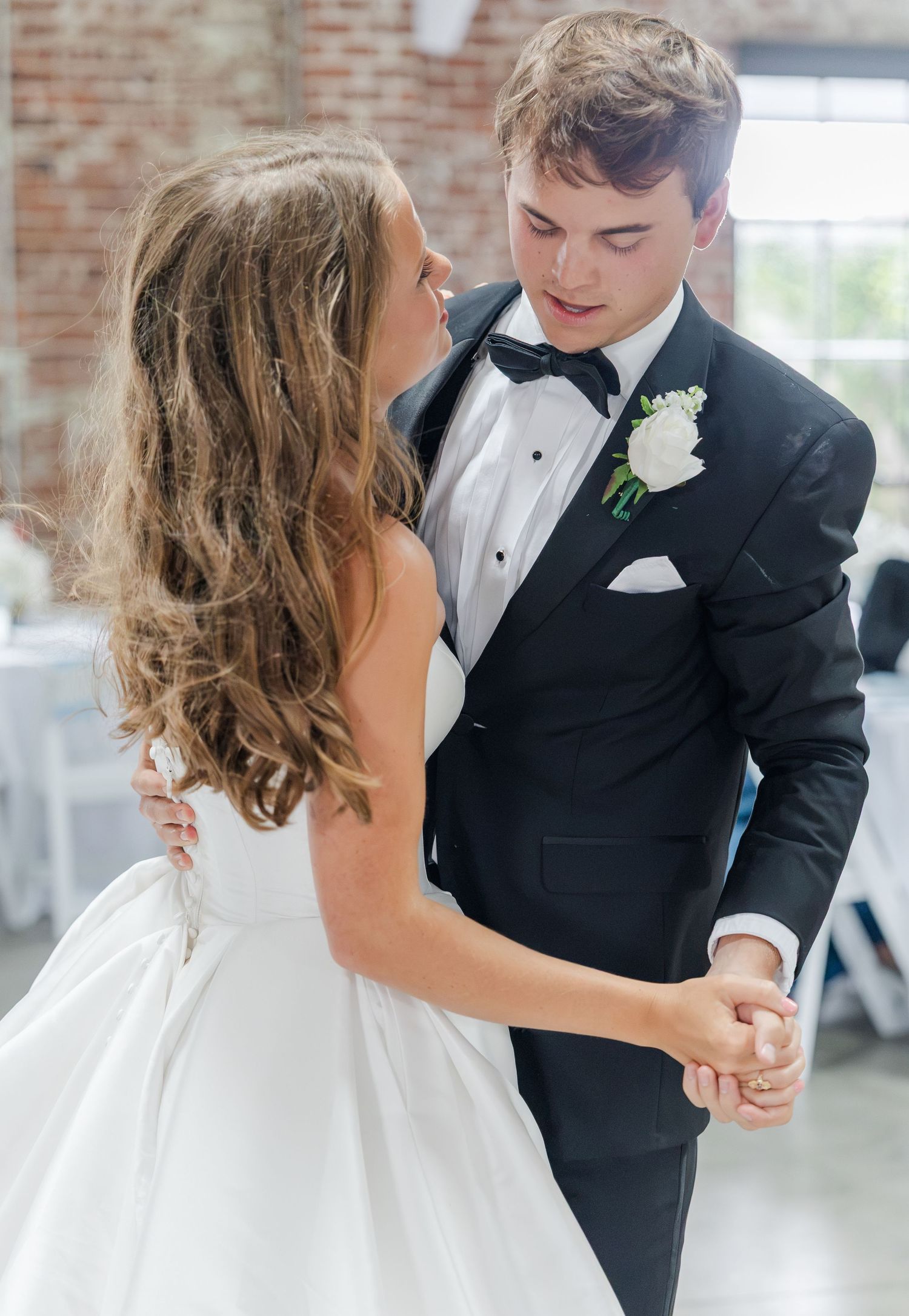 Bride and groom share first dance at elegant wedding reception.