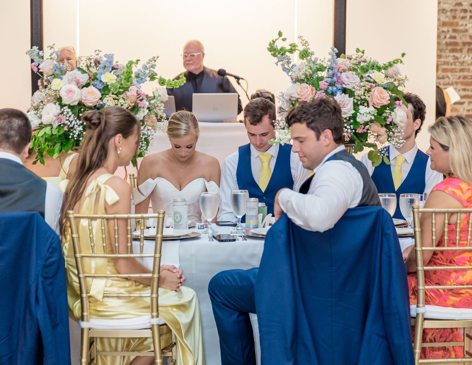 Wedding guests share joyful moments and laughter during a reception celebration at an elegant indoor venue.