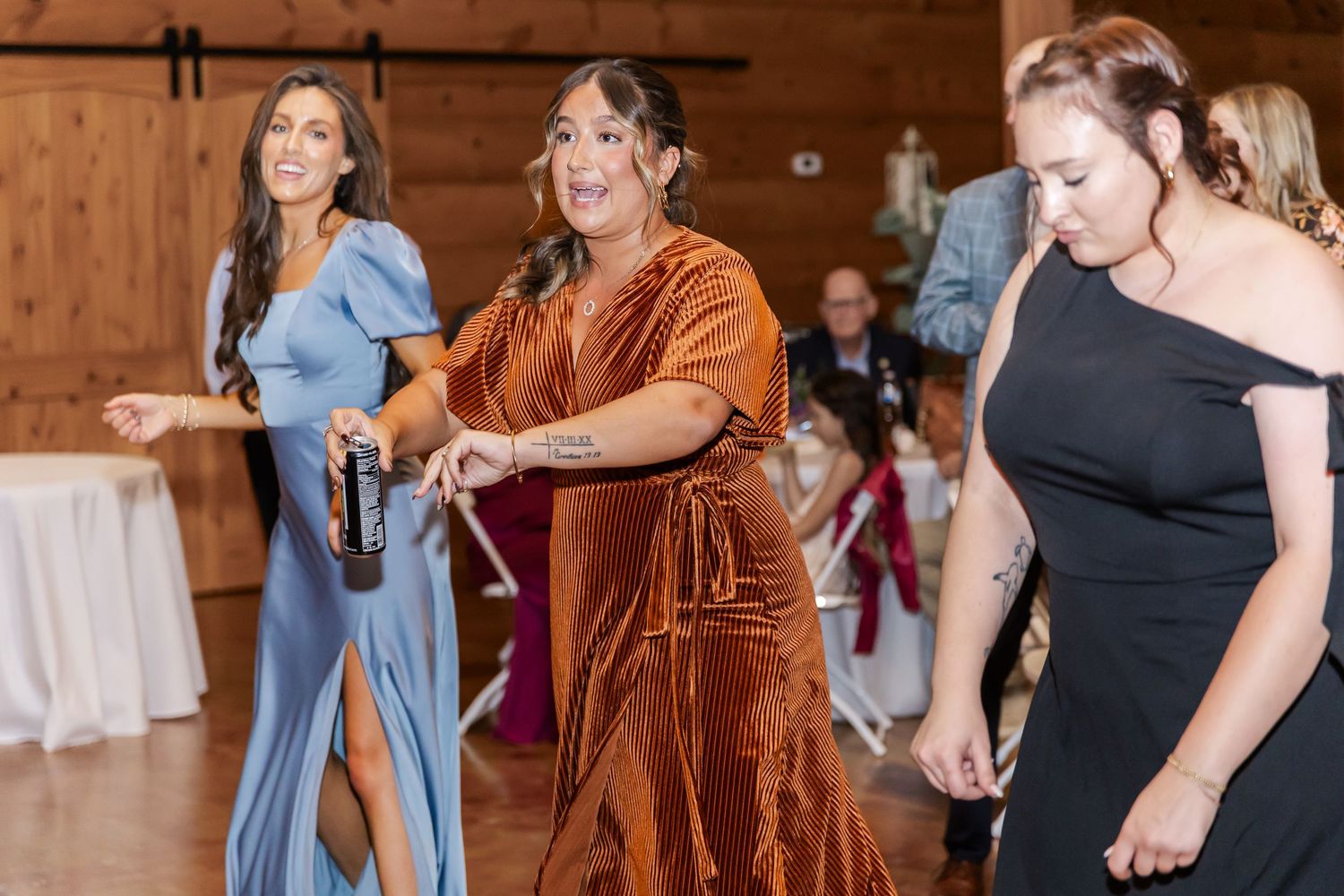Wedding guests dancing and enjoying themselves at a rustic barn reception.