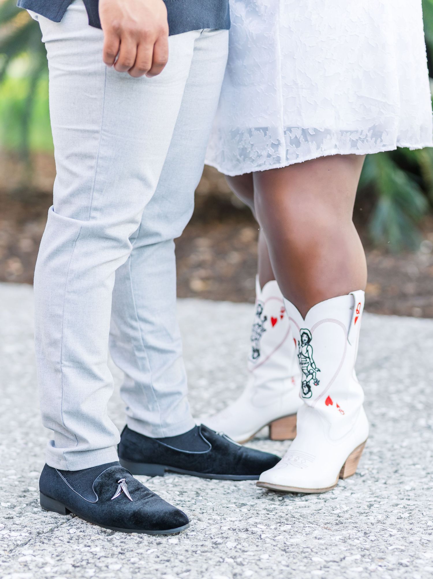 Close-up of contrasting black and white shoes worn by a couple during an outdoor photoshoot.