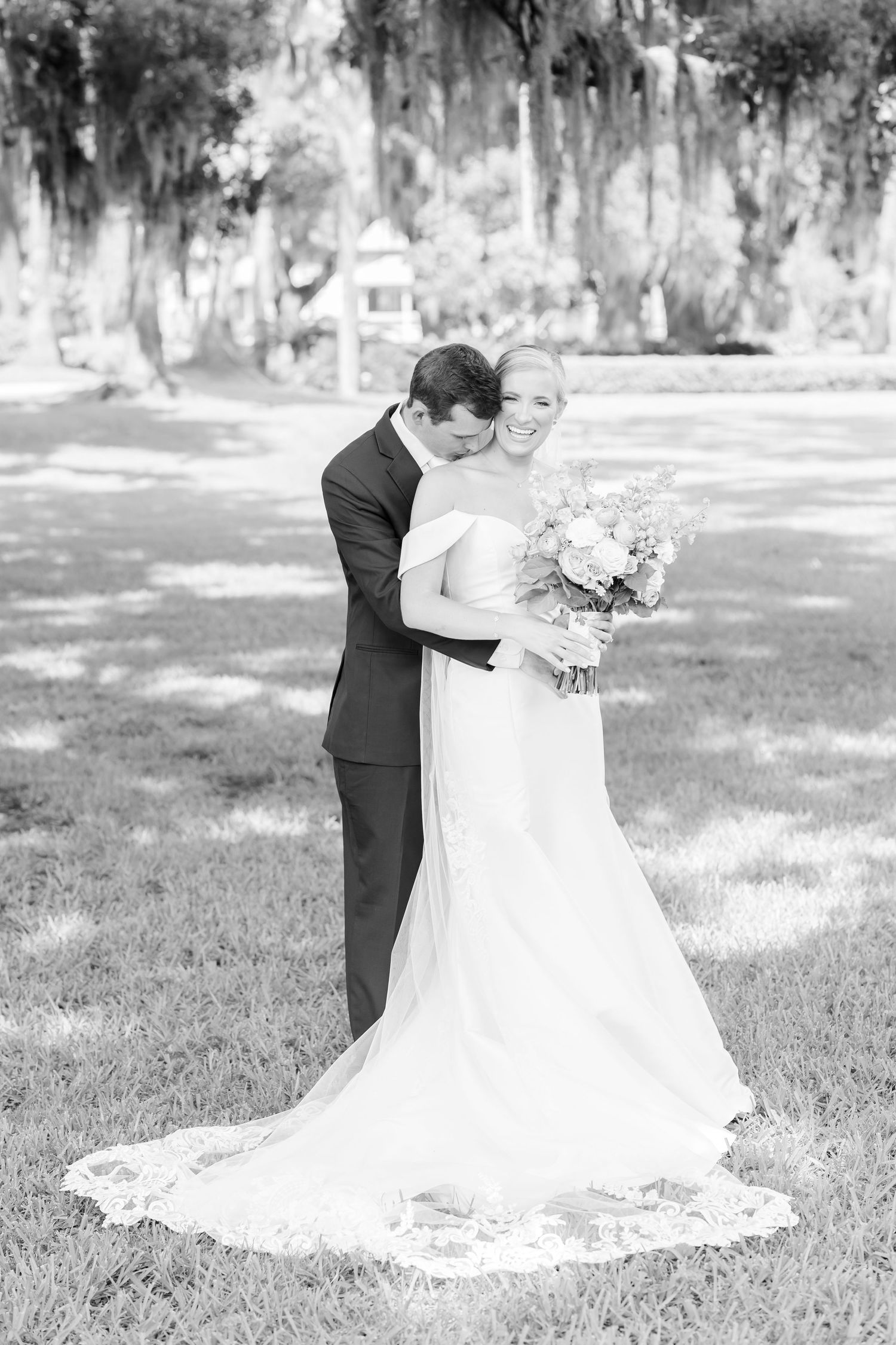 Black and white wedding photos showing a romantic outdoor first look moment between newlyweds in a garden setting.