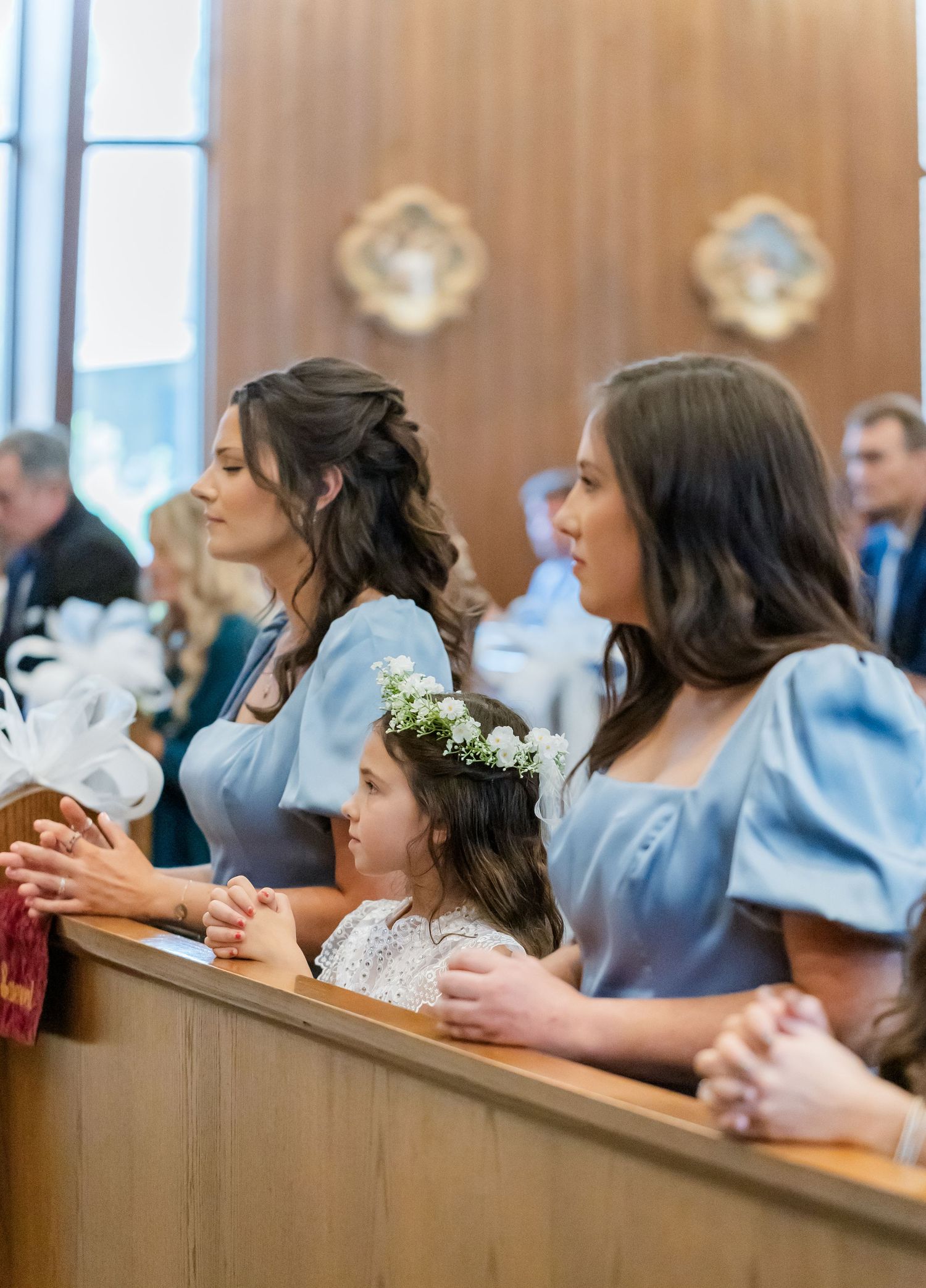 Wedding guests seated in church pews during ceremony.